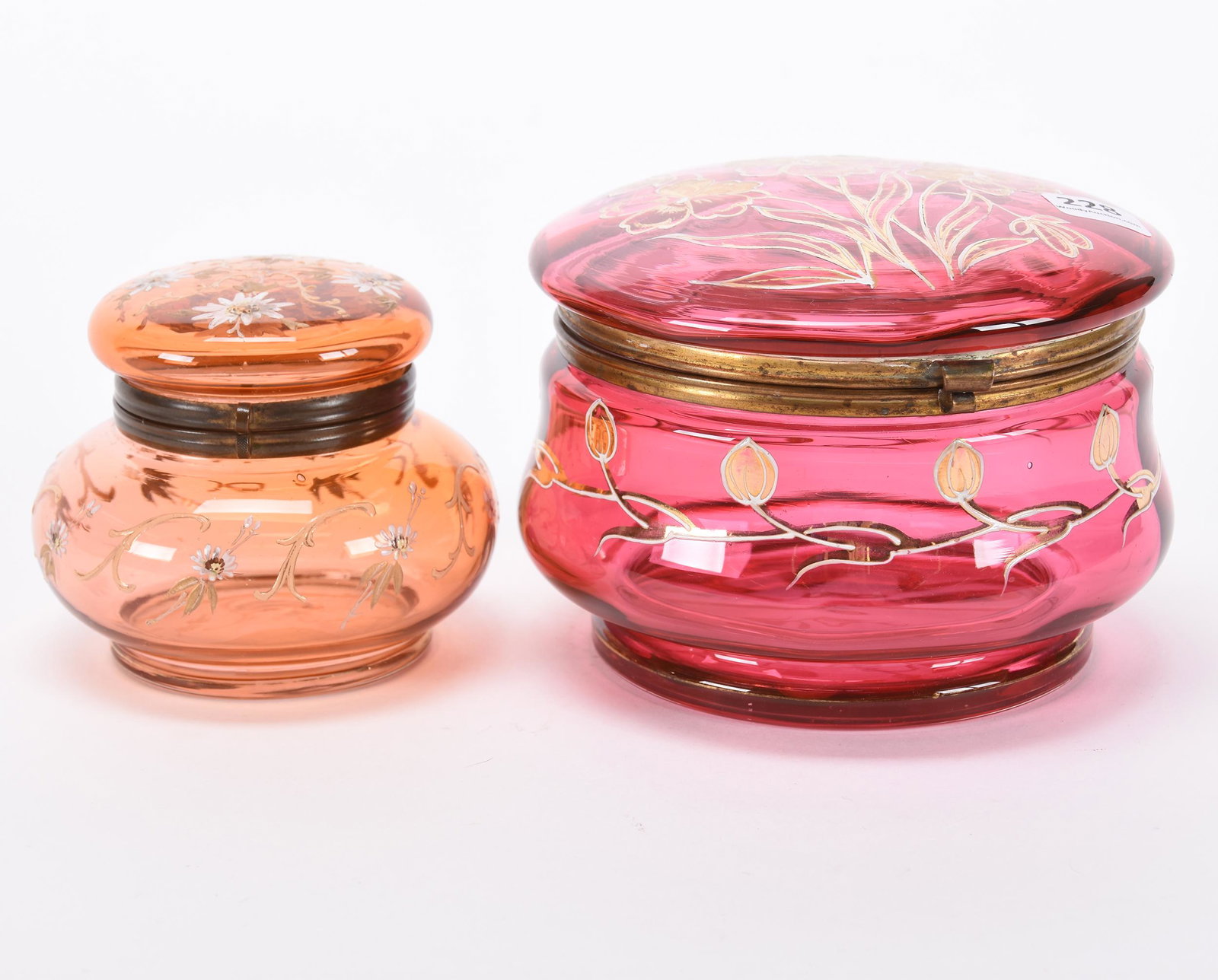 (2) Jewel boxes, round hinged art glass: (2) Jewel boxes, round hinged art glass; 5.5", 4" Both have floral decor; (1) cranberry; (1) apricot; Hopper Collection, Kansas