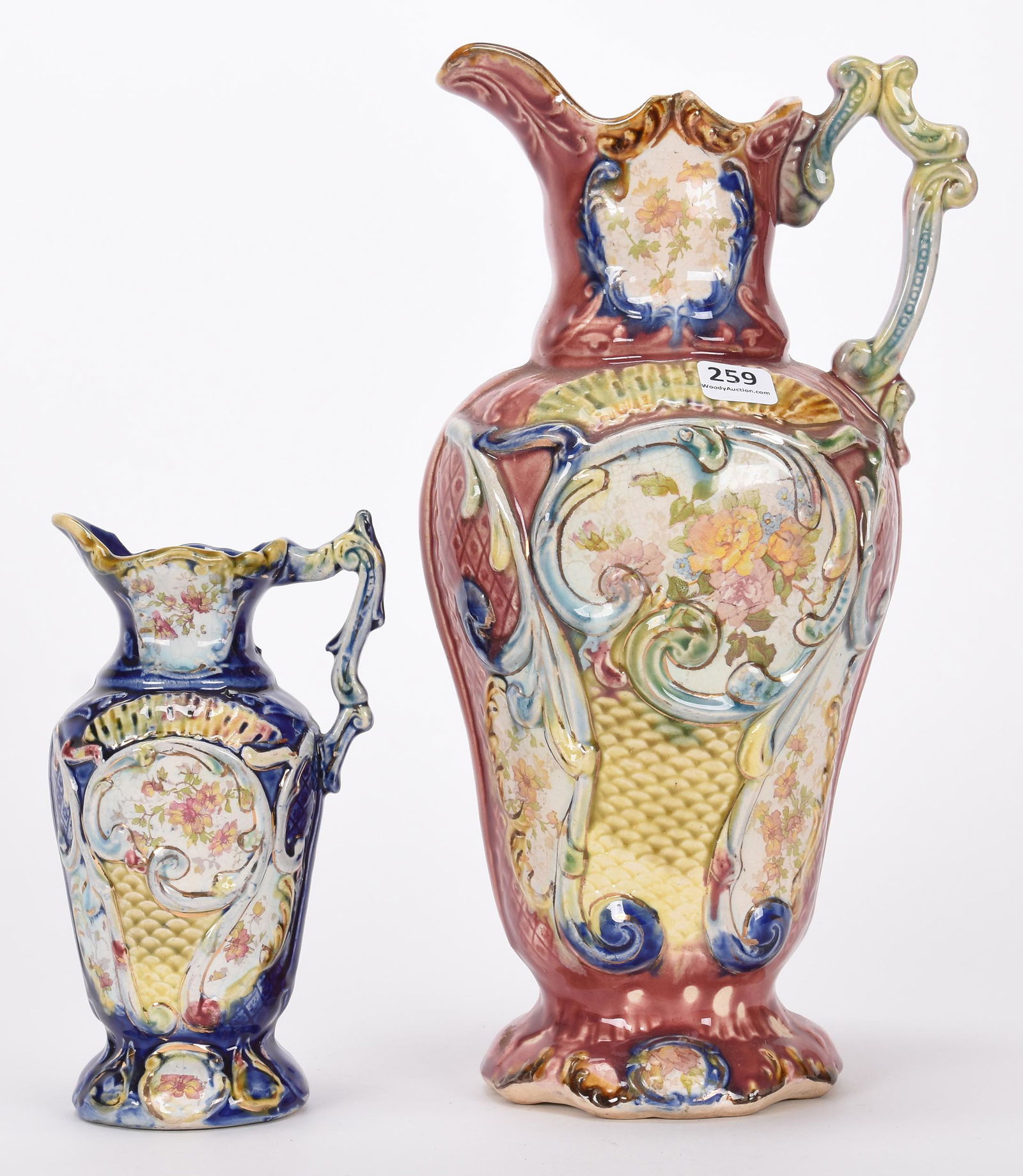(2) Majolica style pitchers: (2) Majolica style pitchers; 12.25", 7" (1) 12.25" maroon tones with floral decor; (1) 7" blue tones with floral decor - nearly identical mold - both are marked "England" Hopper Collection, Kansas
