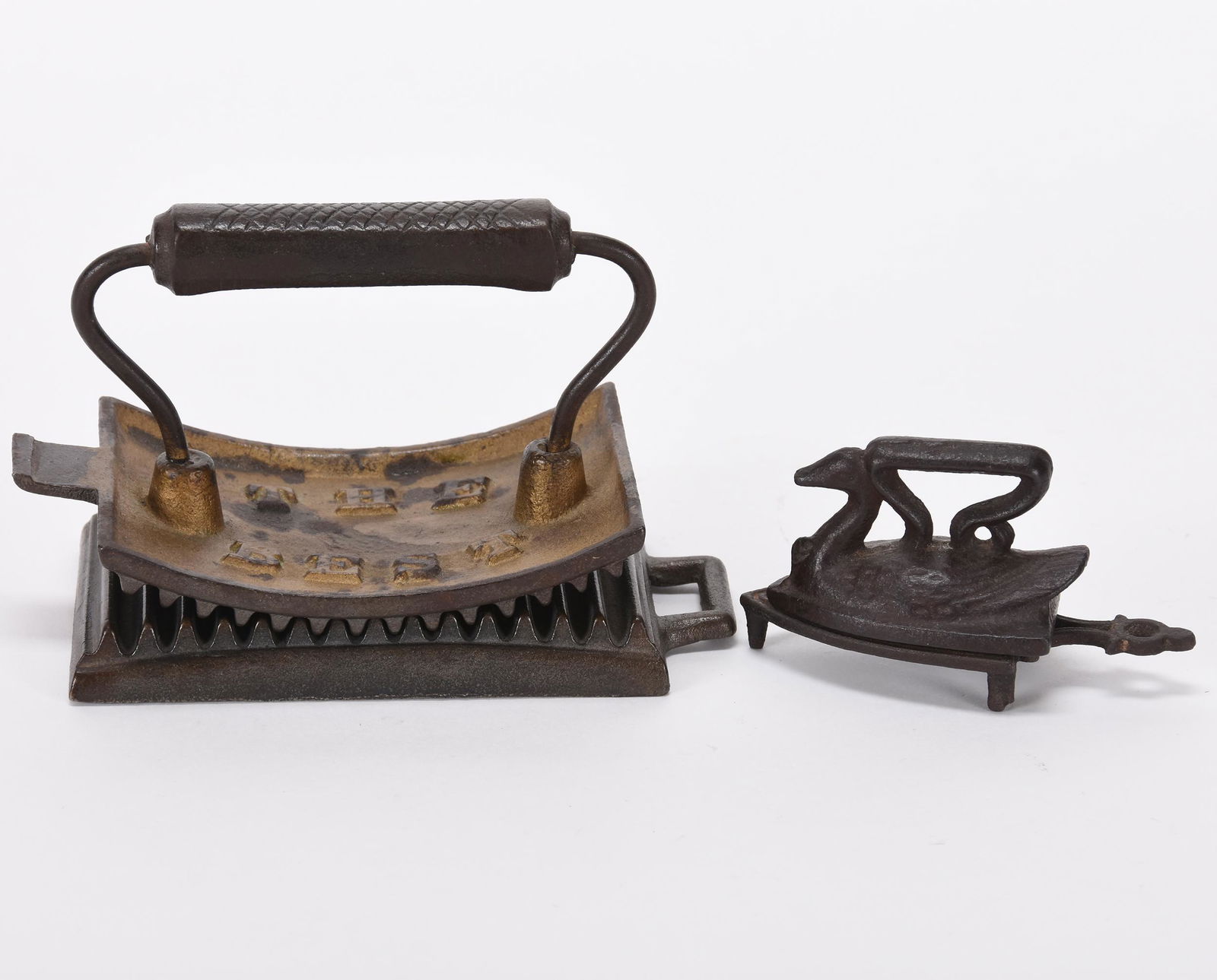 (2) Sadirons, cast iron: (2) Sadirons, cast iron; (1) "The Best" fluting iron by H. Foote Manufacturing, Syracuse, NY; (1) 2.75" Swan toy size iron with trivet; Hanna Collection, Michigan