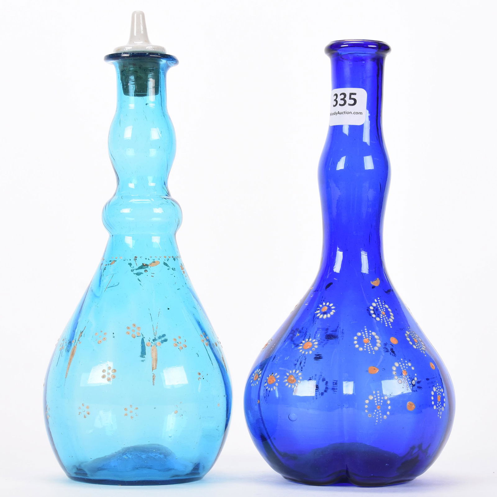 (2) Art glass barber bottles: (2) Art glass barber bottles; 8.25" (1) blue; (1) cobalt blue with enamel floral highlights; Hale Collection, Florida