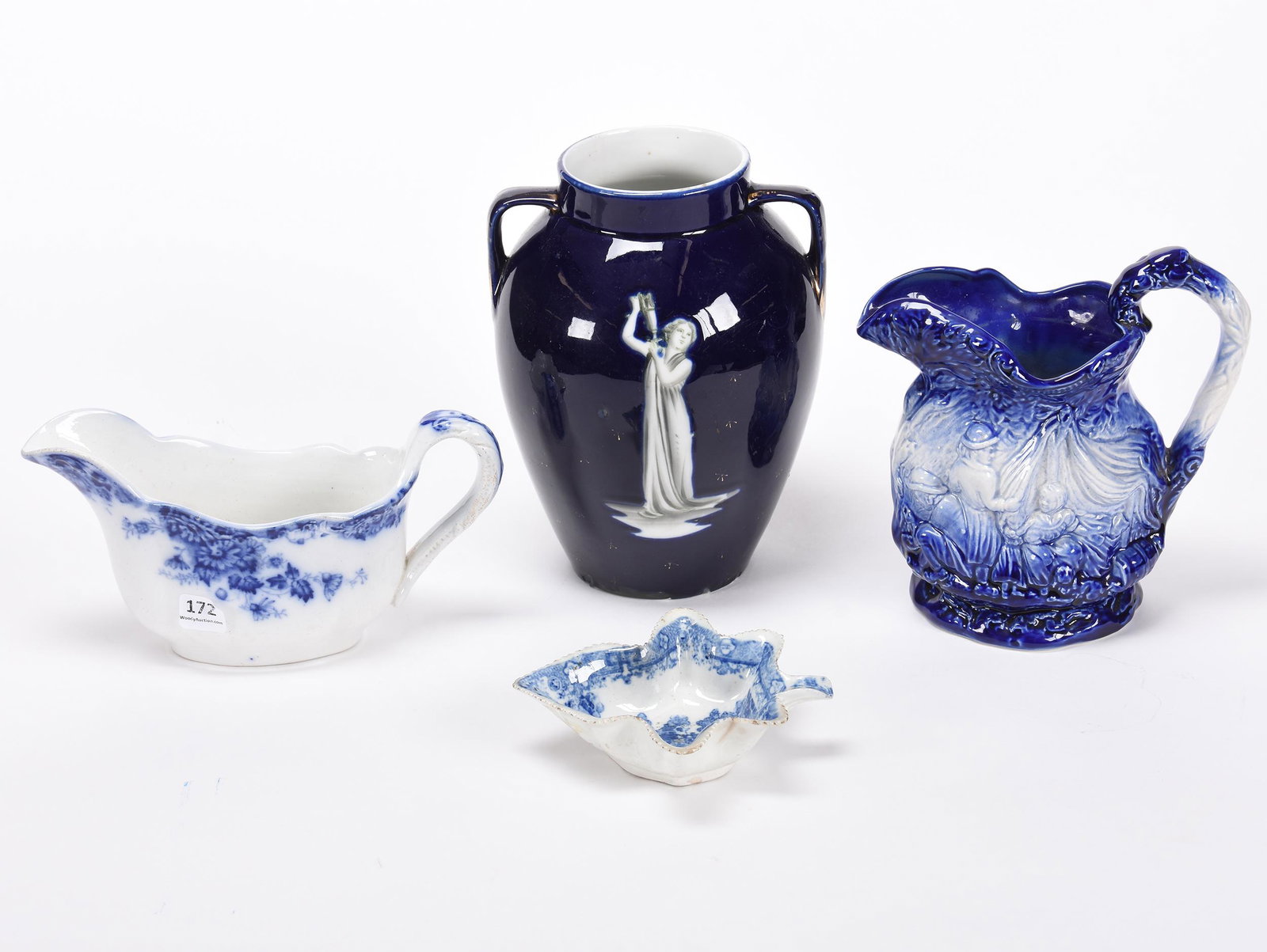 (4) Blue and White Items: (4) Blue and White Items; (1) 8.25" Marked "Fedora" Vase, Cobalt Blue with Figure of Woman Holding Vase, (1) 7" Pitcher, Staffordshire Embossed Ironstone, Camping Scenic Decor, (1) 4.5 X 8" Gravy Boat
