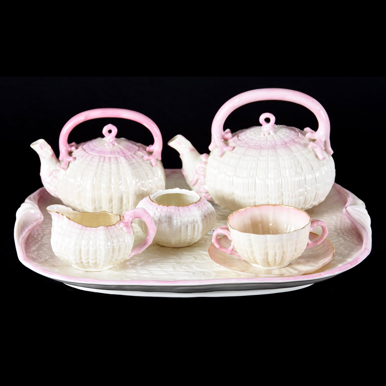 (6) Pc. Tea Set, Irish Belleek Black Mark, Tridacna: (6) Pc. Tea Set, Irish Belleek Black Mark, Tridacna, (1) 15.5" Serving Tray, (1) 5.75" x 7.5" Teapot, (1) 5" x 6" Teapot, Creamer, Sugar (No Lid), Bouillon Cup & Saucer, Pink Highlights, from the esta