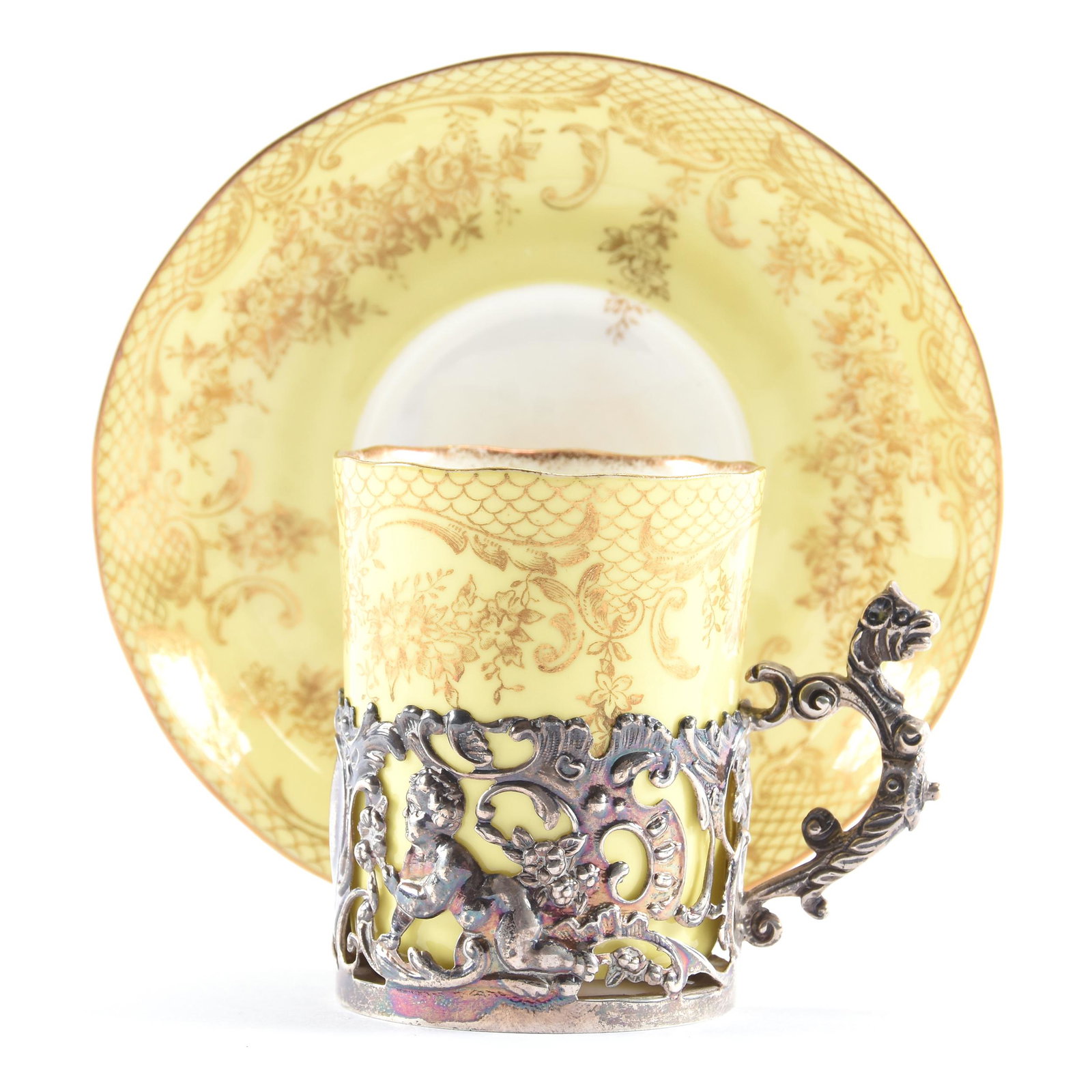 Cup & Saucer Marked Staffordshire Egg Shell: Cup & Saucer Marked Staffordshire Egg Shell, 2.75" x 4.5", Yellow with Gold Stencil Floral Decor, Cup Set in Ornate Silver Holder with Dragon and Cherub Design, Eseline Reynolds Estate