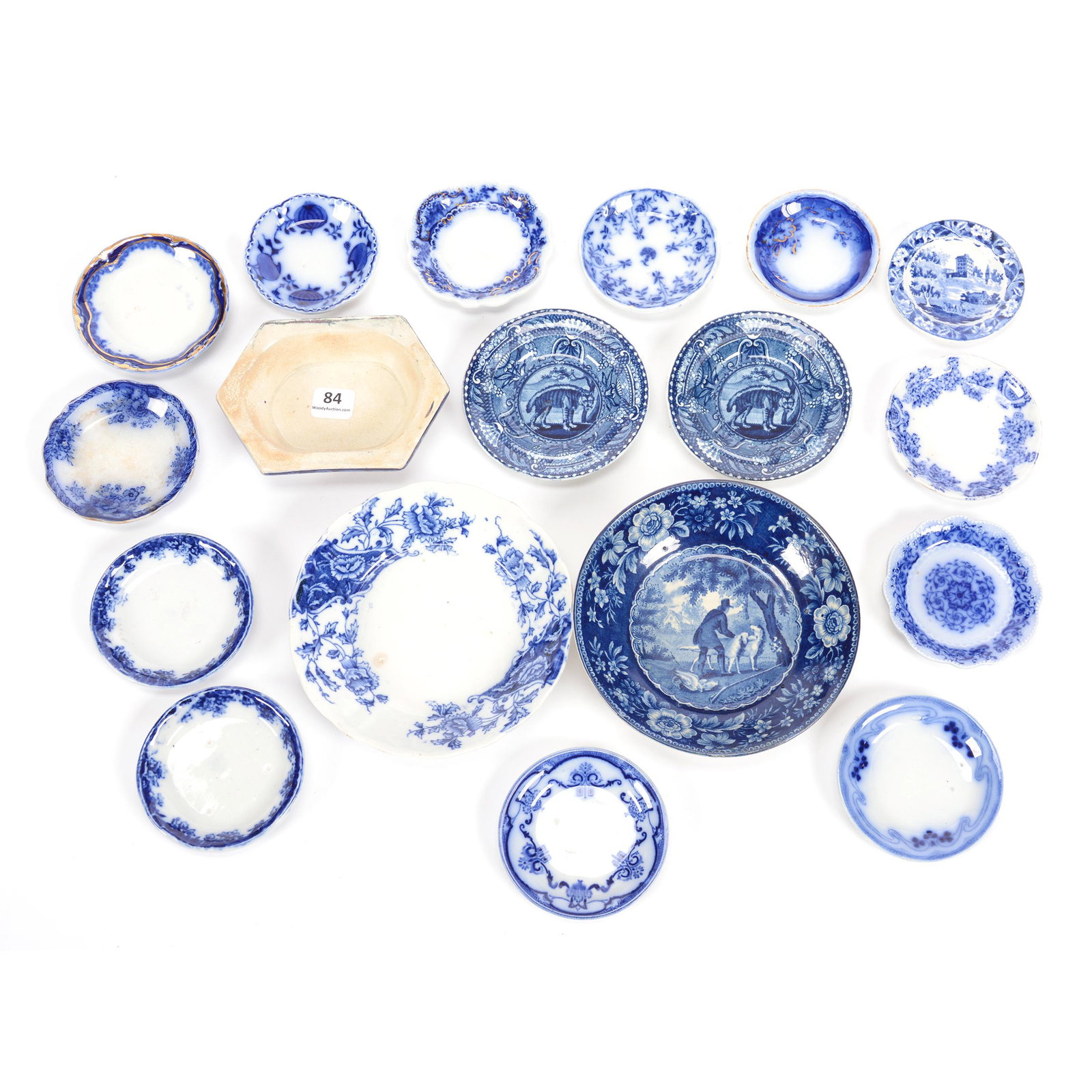 (17) Assorted Flow Blue Items: (17) Assorted Flow Blue Items, (12) Butter Pats in Various Patterns, (2) 4" Child Size Saucers with Decor of Extinct Tasmanian Tiger, (2) Berry Bowls, One in Rudyard Pattern, One with Hunter and Dogs,