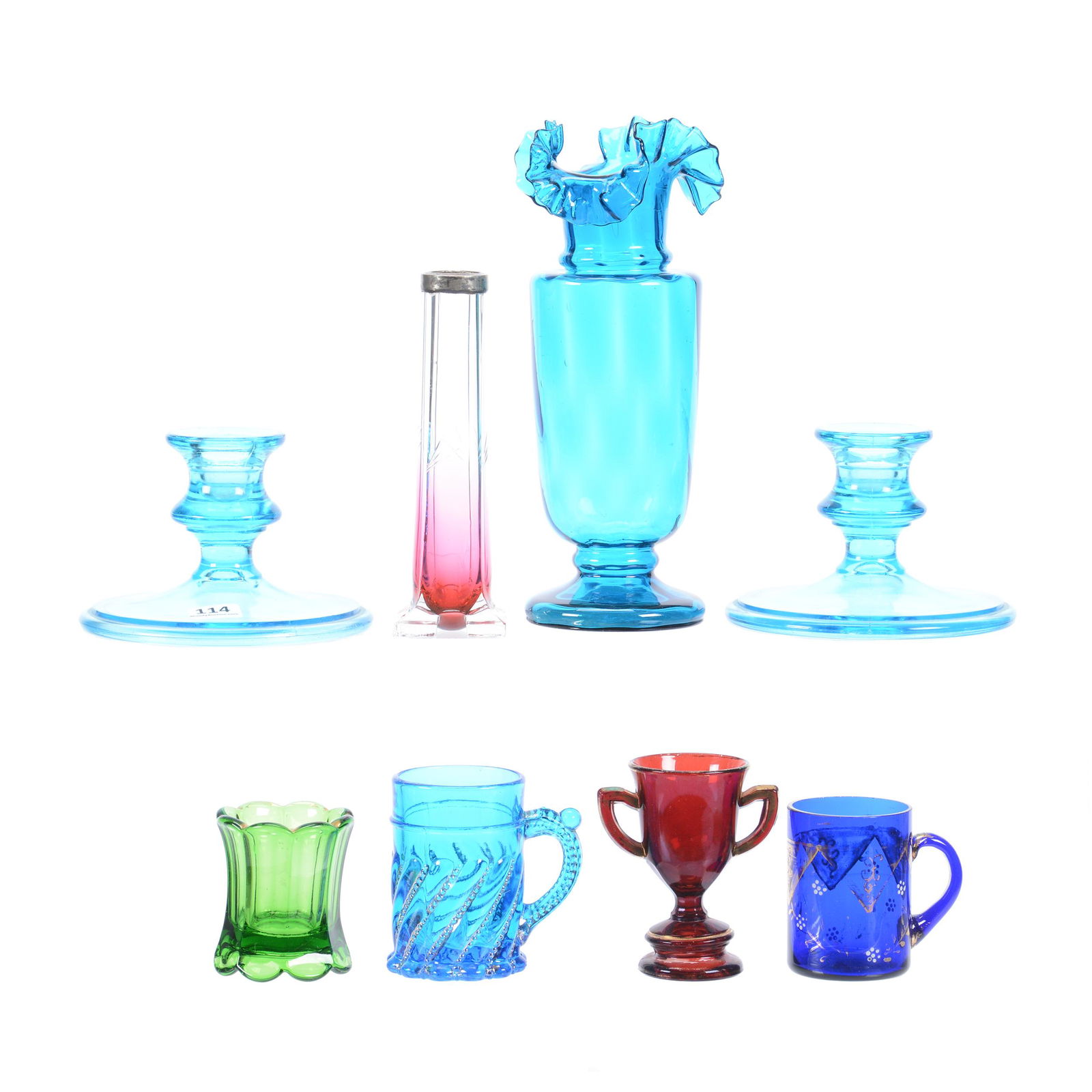 (8) Colored Glass Items: (8) Colored Glass Items, (1) 8.5" Blue Ruffled Art Glass Vase, (1) 6" Rubina Bud Vase, (1) Ruby Flash Toothpick Holder in Form of Trophy, (1) 3.25" Blue Mug, (1) 2.75" Cobalt Blue Mug, (1) 2.25" Green