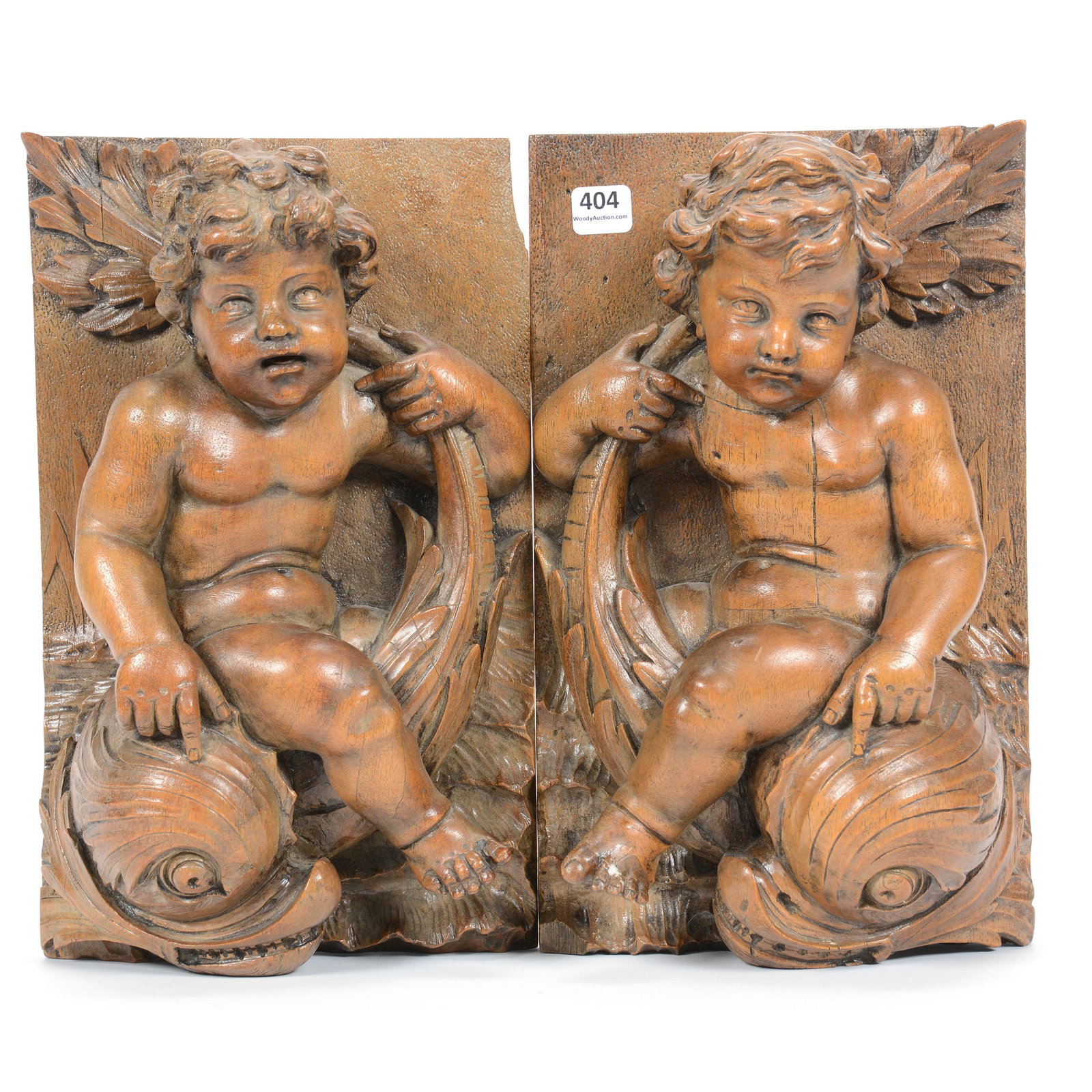 Carved Wooden Plaques, Three Dimensional: Carved Wooden Plaques, Three Dimensional, 12" X 7.5", Mirror Images of Cherubs Riding Dolphins, One Plaque has Cherub with Two Toes Repaired; the Collection of Mrs. R. and the Late Dr. S. Alexander.