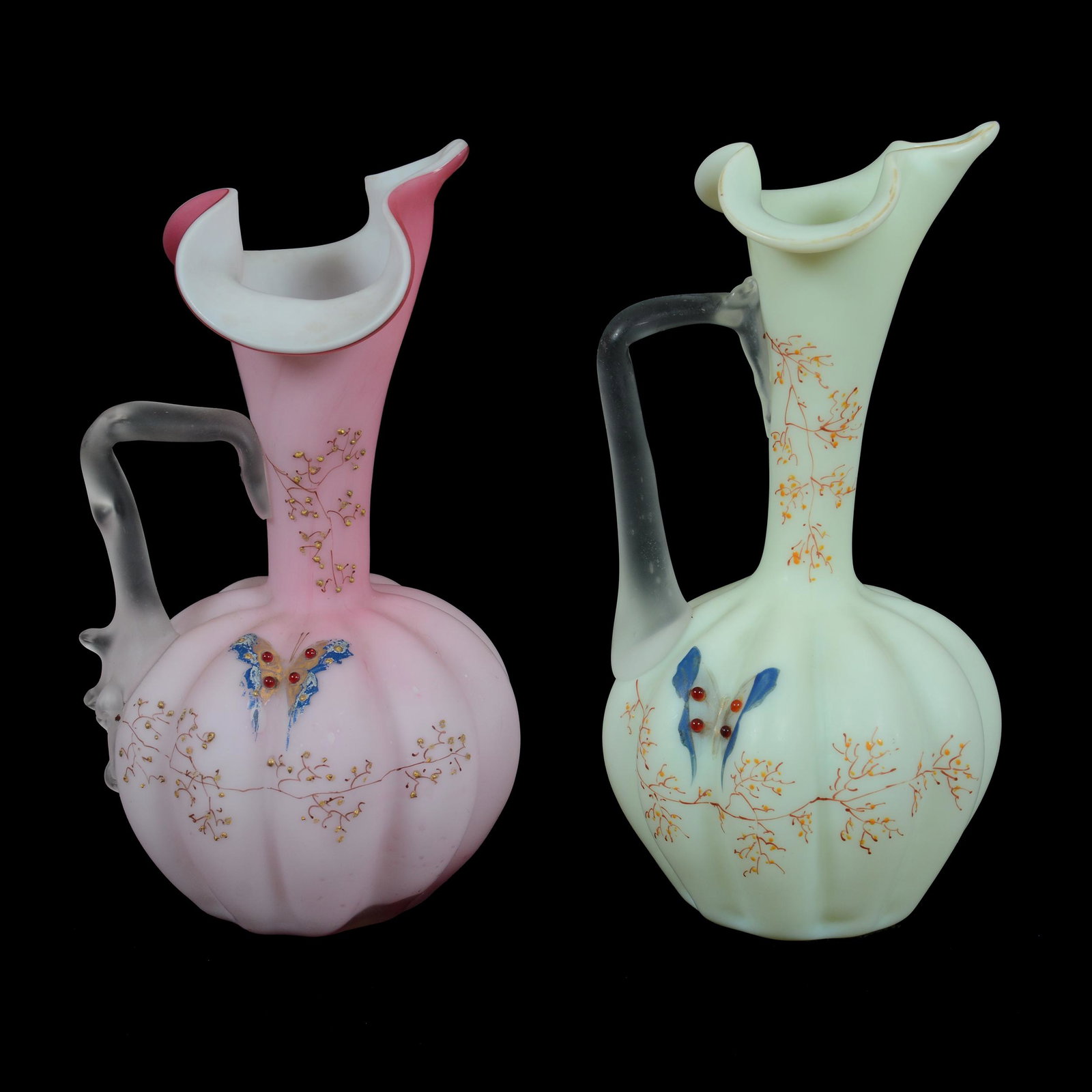 (2) Ewers, Satin Art Glass: (2) Ewers, Satin Art Glass, Butterfly And Branch Decor With Applied Jewel Highlights, Melon Ribbed With Applied Frosted Handles, (1) 8.25", Cream, (1) 8", Pink, John Lolley Estate. Mr. Lolley Regularl