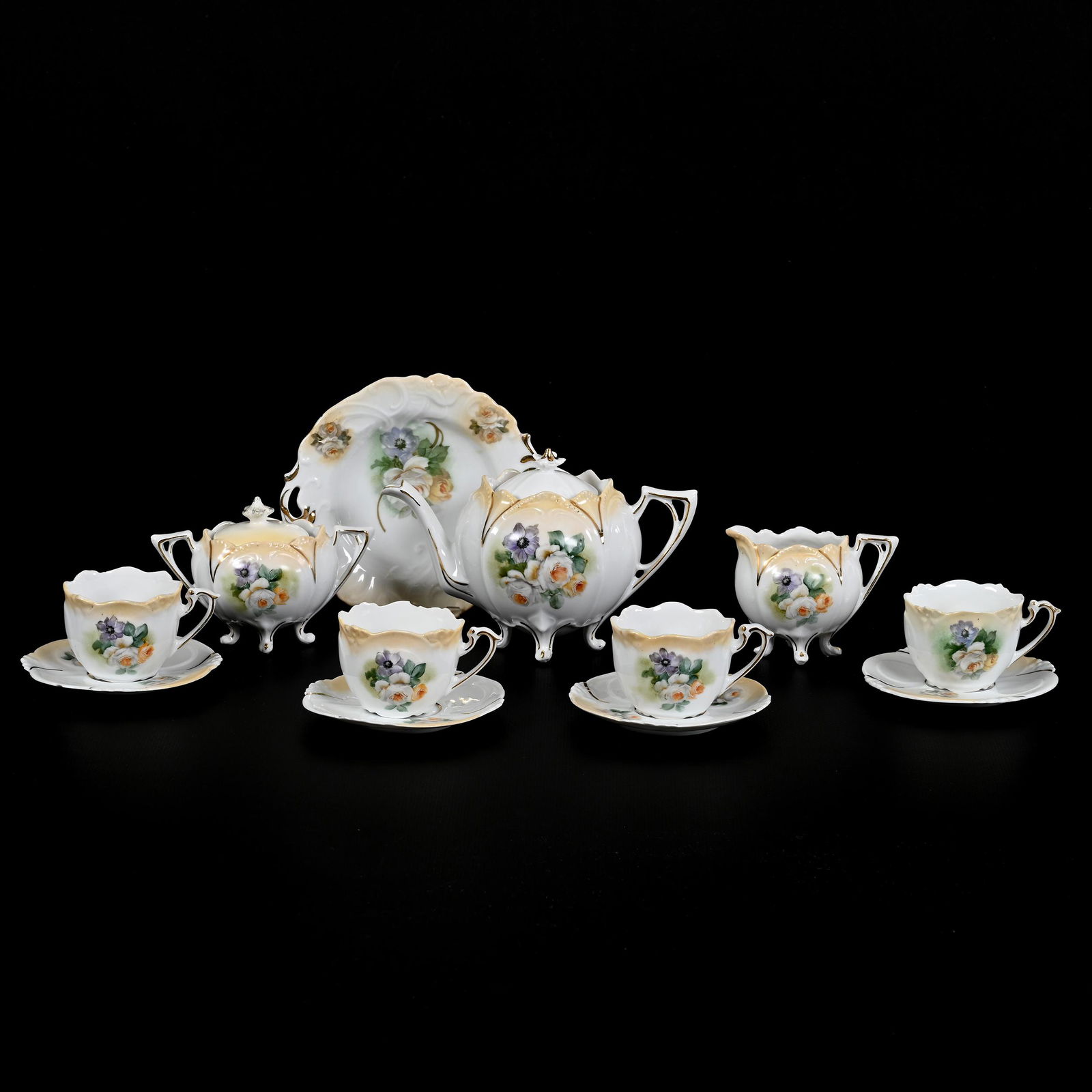 Child's Tea Set, Unmarked R.S. Prussia, (12) Piece: Child's Tea Set, Unmarked R.S. Prussia, (12) Piece, White And Cream Tones With Floral Decor, (1) 4.25" X 6.25" Tea Pot, (1) Creamer and Sugar Set, Sugar Lid Restored, (4) Cups And Saucers, One Cup Wit