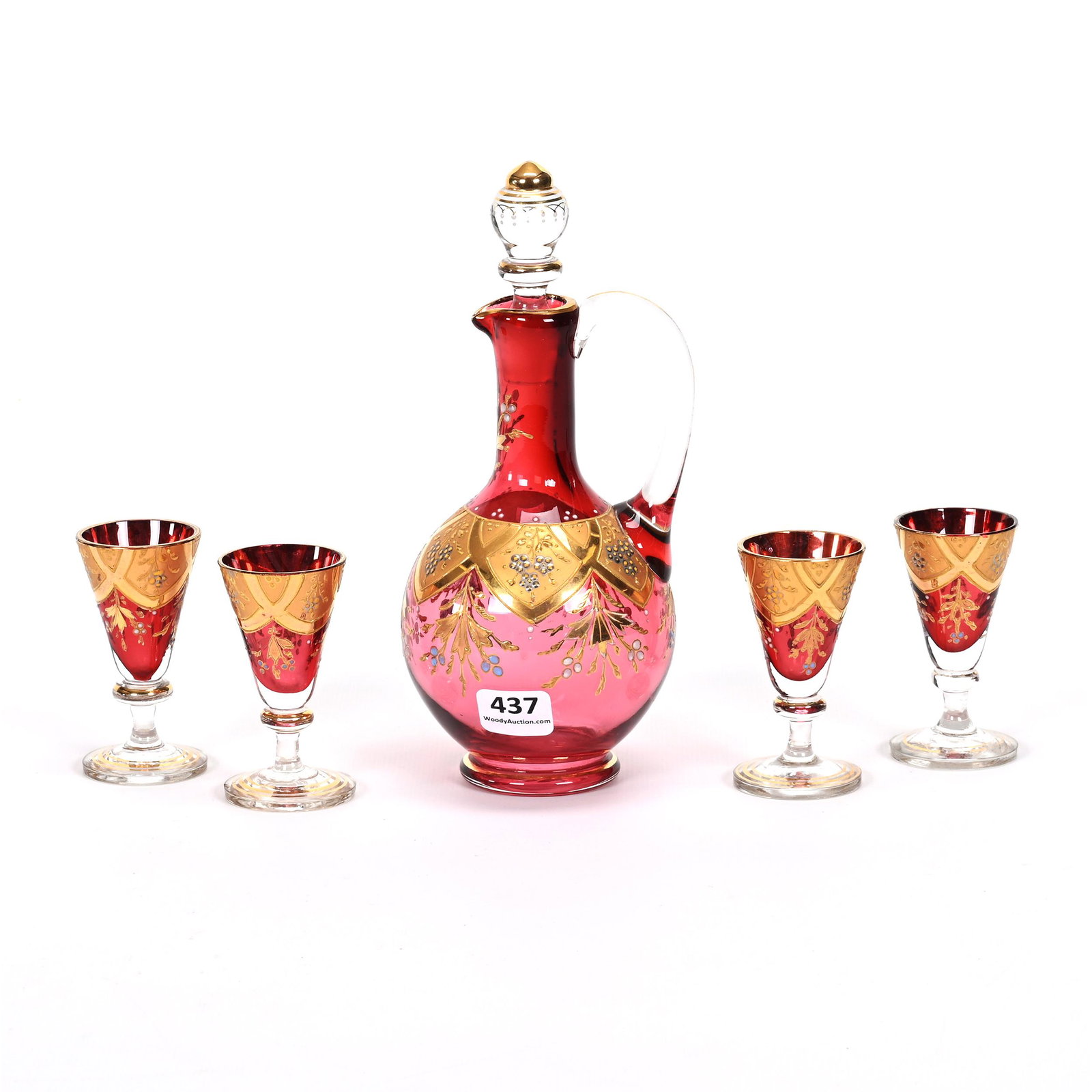 Decanter Set, Cranberry Art Glass: Decanter Set, Cranberry Art Glass, Gold And Silver Enamel Floral Highlights, (1) 7.5" X 3.25" Decanter, Handle Crack, (4) Matching 3" Cordial Stems, Mike & Mary Ann Callahan Collection.