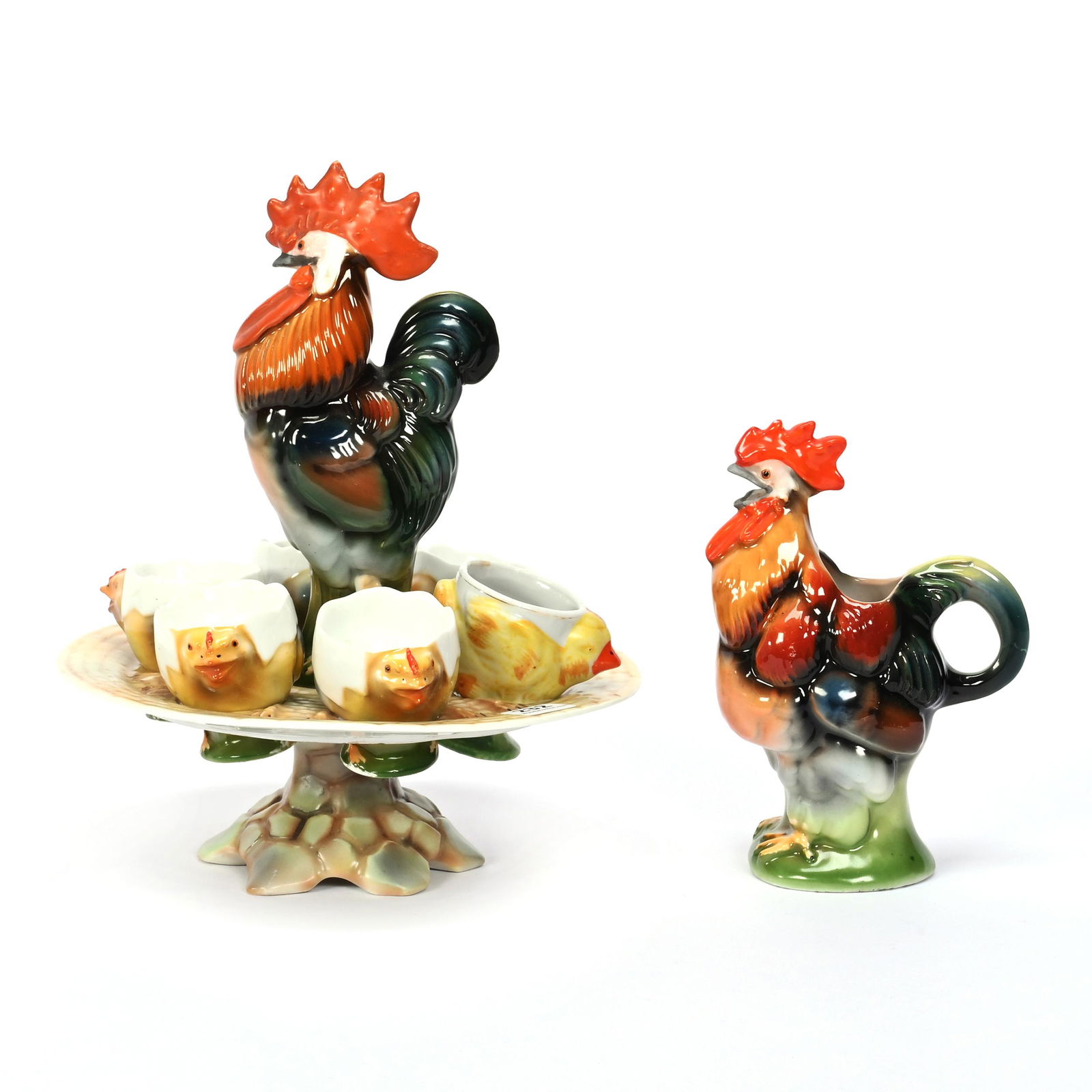 (2) Items, Germany Figural Porcelain: (2) Items, Germany Figural Porcelain, (1) 9.5" x 8" Egg Server With Rooster Center And Platter Holding Six Egg Cups, One Egg Cup Is Replacement And Does Not Fit Properly, (1) 6.25" Rooster Creamer Mar