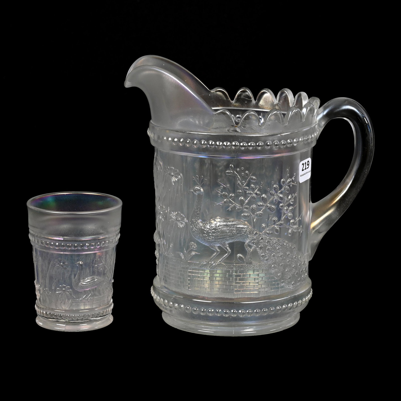 Water Set, Carnival Glass, Peacock At Fountain, White: Water Set, Carnival Glass, Peacock At Fountain, White, By Northwood, (1) 8.5" Pitcher, Side Surface Chip Below Tooth, Sells With (1) 4" Tumbler, Two Base Chips, Dick & Diane Elder Collection.