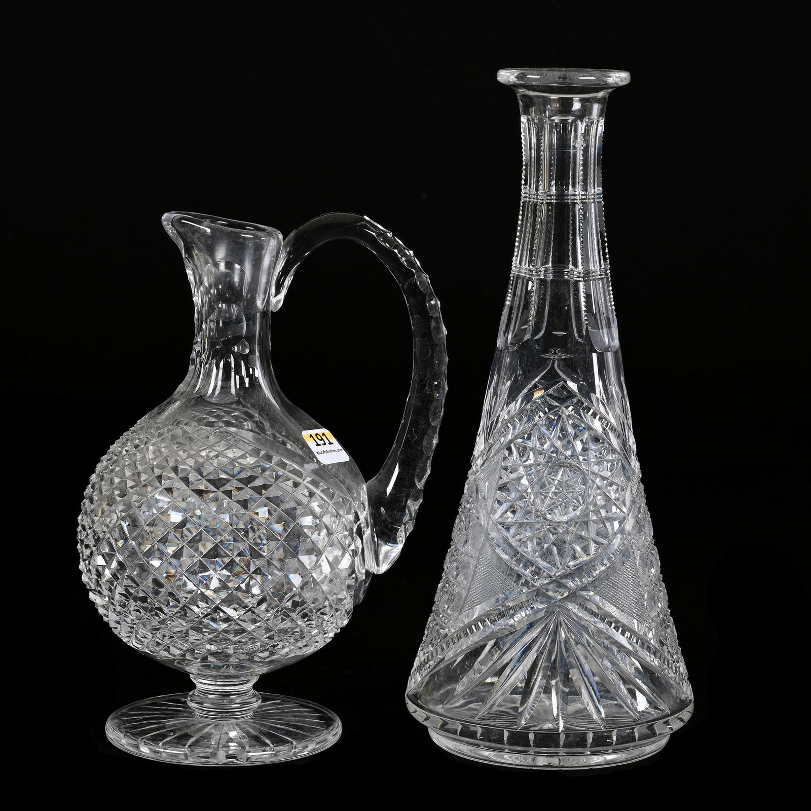 (2) Decanters, American Brilliant Cut Glass: (2) Decanters, American Brilliant Cut Glass, (1) 9" x 6", Diamond Cut Body, Triple Notched Handle, Ray Cut Foot, No Stopper, (1) 11" x 4.75", Hobstar, Cane, Strawberry Diamond, Prism And Fan Motif, No
