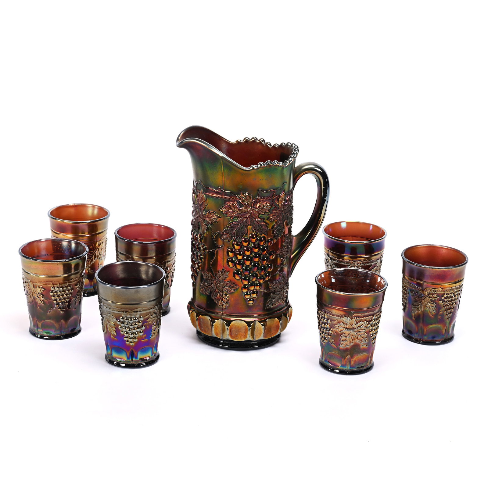 Tankard Set, Carnival Glass, Northwood Grape & Cable: Tankard Set, Carnival Glass, Northwood Grape & Cable, Amethyst, (1) 9.75" x 7" Tankard, (7) 4" Tumblers, One Tumbler Has Base Chip, One Tumbler Has Convex Base, Kansas Private Collection.