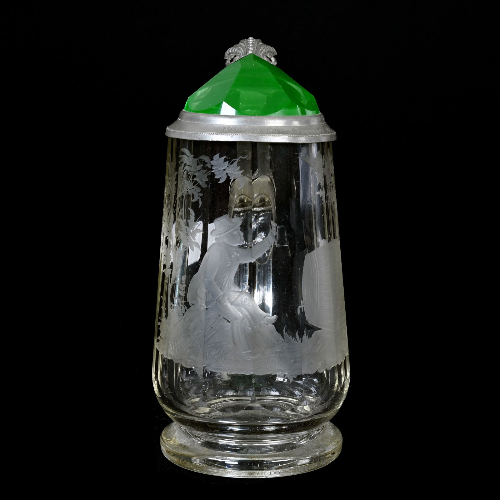 Stein, Clear Bohemian Art Glass Body: Stein, Clear Bohemian Art Glass Body, 7.5" x 5", Engraved Scene Of Man Near Keg, Pewter Flip Lid With Engraving Dated 1909, Encased Uranium Green "Jewel" Center Of Lid, Highly Reactive Under Black Lig