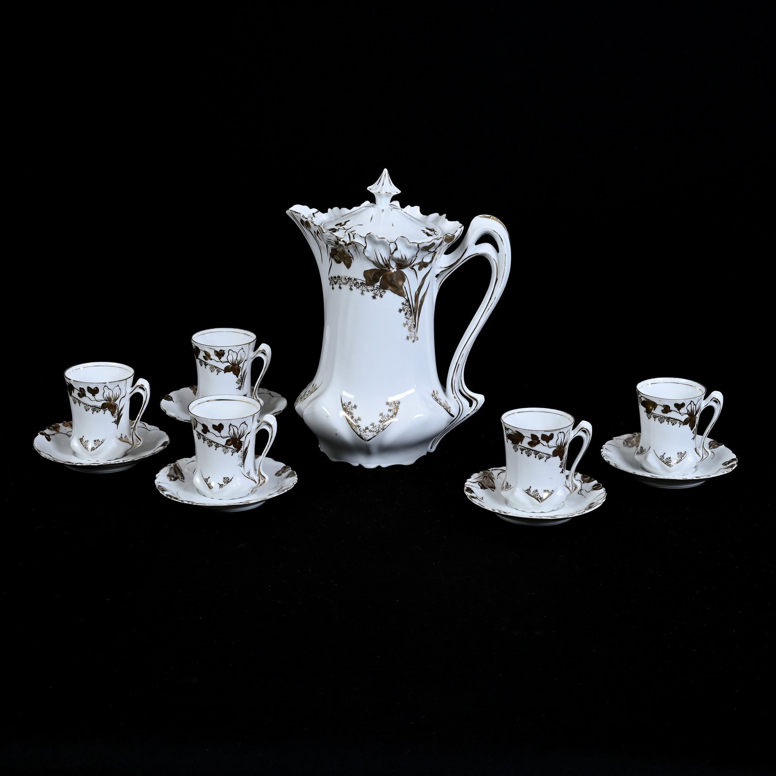 Chocolate Set, Unmarked R. S. Prussia: Chocolate Set, Unmarked R. S. Prussia, Iris Variation Mold, White With Gold Trim, (1) 9.5" x 7.25" Chocolate Pot, (5) Matching Cups And Saucers, One Cup With Two Rim Chips, One Cup With Rim Crack, Ill