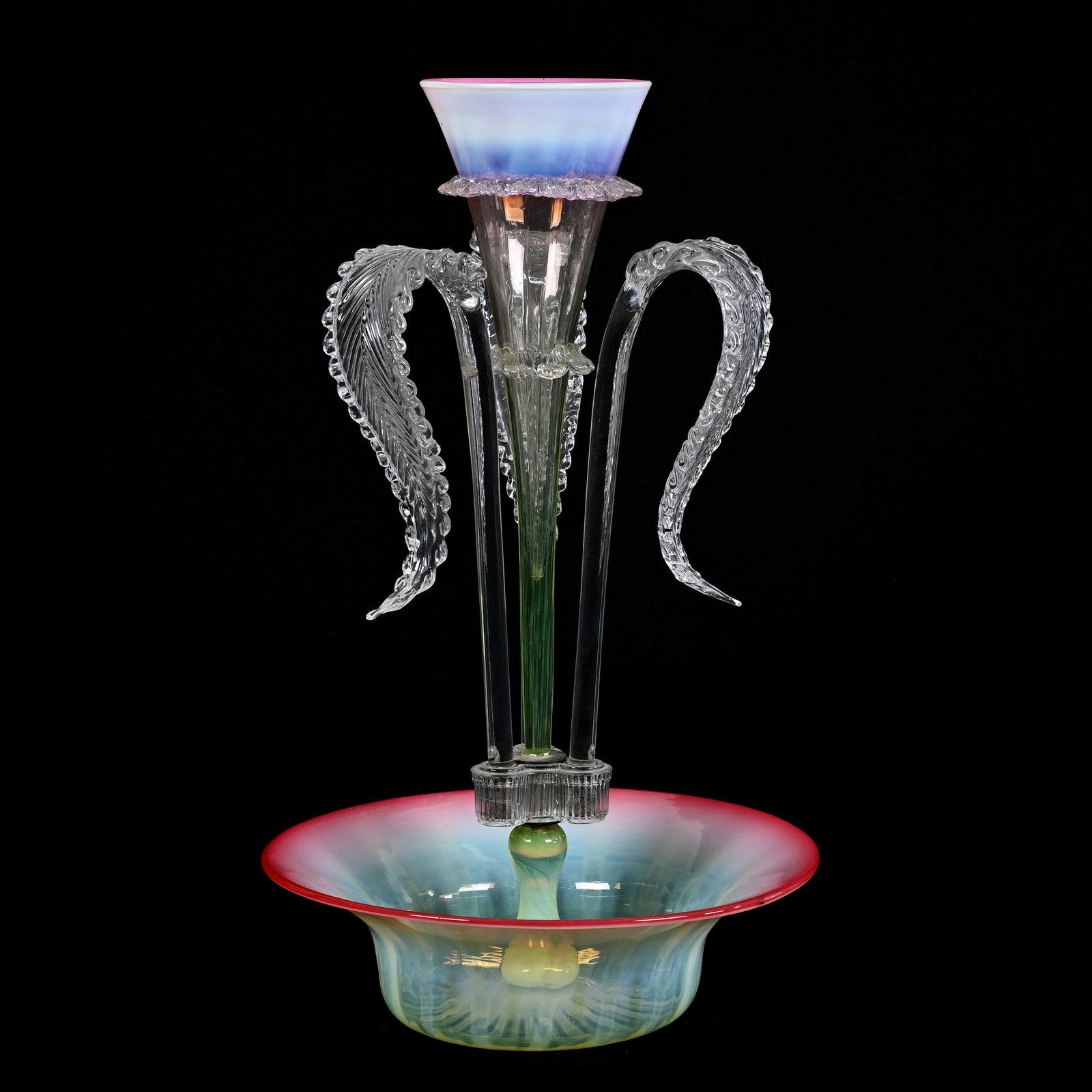 Epergne, Single Lily, Cranberry Vaseline Opalescent Art Glass: Epergne, Single Lily, Cranberry Vaseline Opalescent Art Glass, 19" x 11", Three Clear Curved Glass Leaves Surrounding Center Lily, Highly Reactive Under Black Light, Piece Holding Lilies Is Chipped An