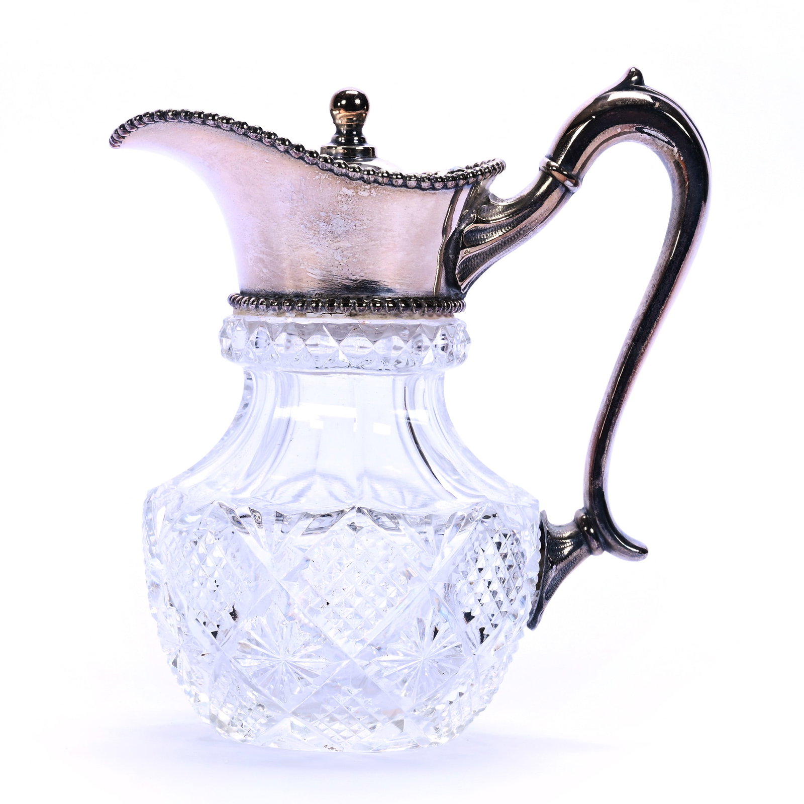 Syrup Pitcher, American Brilliant Cut Glass, Crosshatch, Diamond And Star Motif: Syrup Pitcher, American Brilliant Cut Glass, Crosshatch, Diamond And Star Motif, 5" x 4.5", Ray Cut Base, Silverplate Spout, Lid And Handle, Georgia Private Collection.