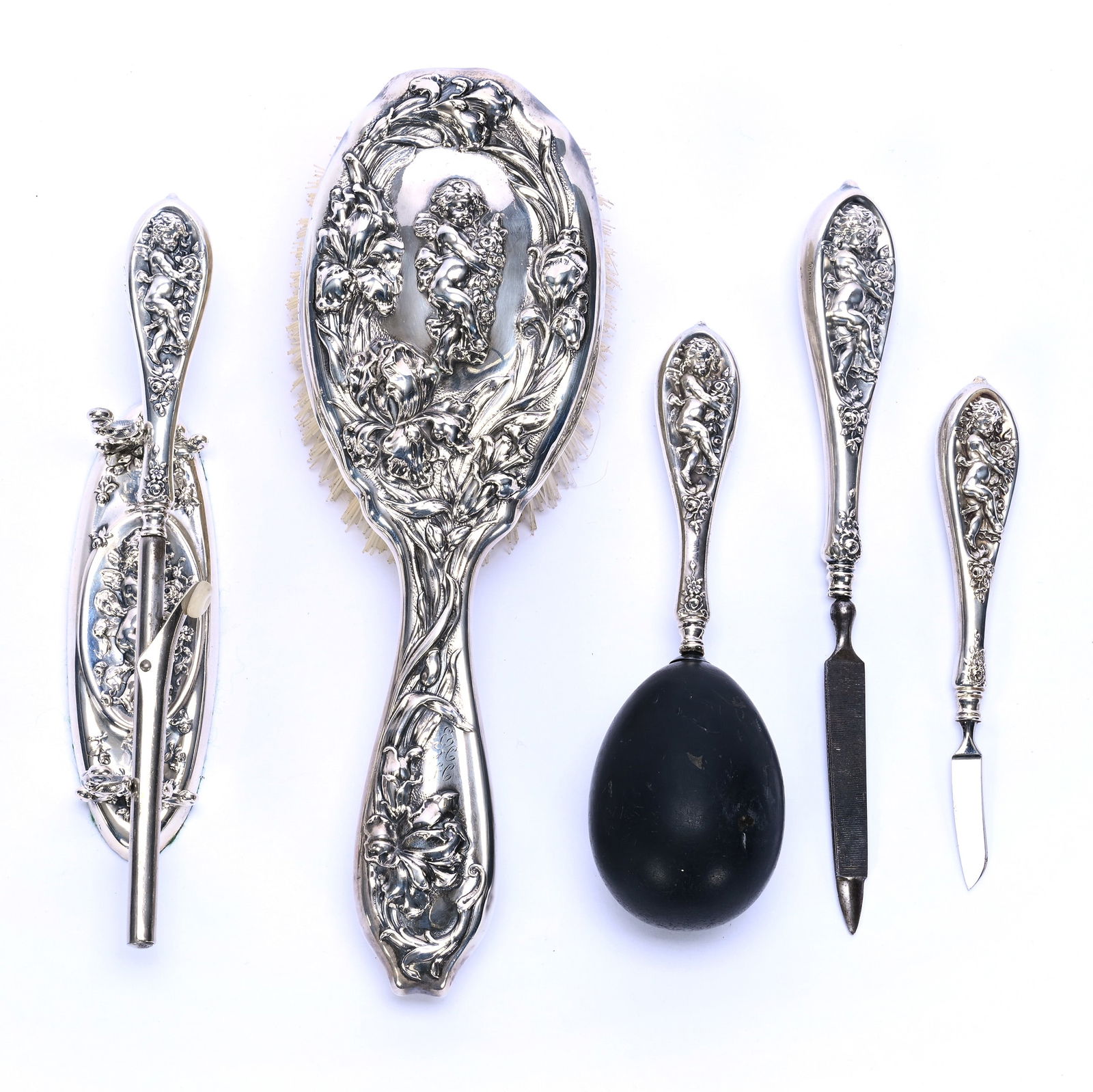 Dresser Set Marked Woodside Sterling (1896-1925), Six Piece, Embossed Winged Cherub Design: Dresser Set Marked Woodside Sterling (1896-1925), Six Piece, Embossed Winged Cherub Design, (1) 9" Hair Brush, (1) 7.5" File, (1) 5" Cuticle Knife, (1) 7.5" Curler, (1) 6" Darner, (1) 1.75" x 4.5" Wei
