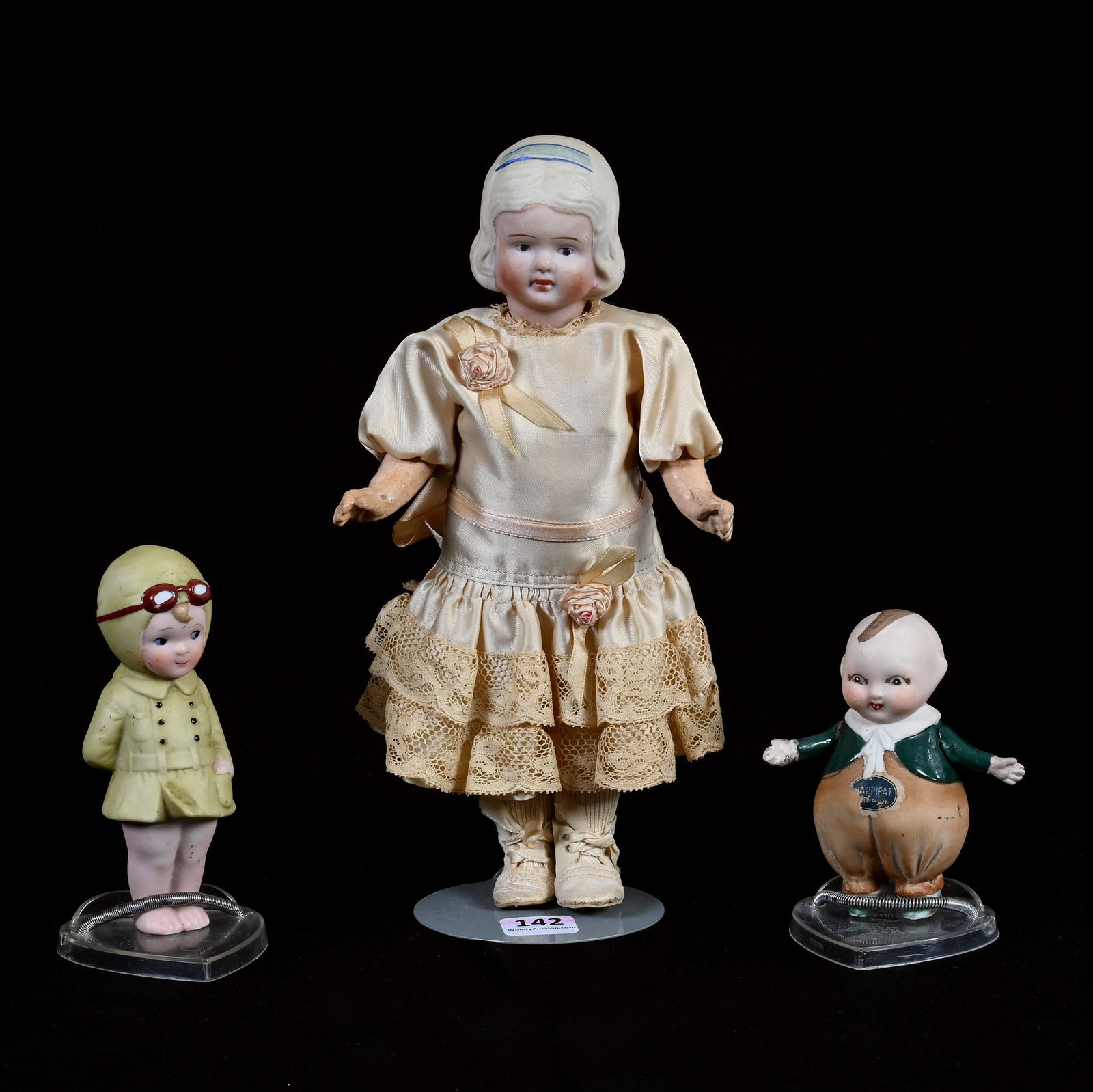 (3) Japanese Bisque Dolls Marked Nippon: (3) Japanese Bisque Dolls Marked Nippon, (1) 9" Composition Body, Silk Dress, (1) 4.5" Pilot, (1) 3.5" Happifat, 0.7 Pounds, Dr. Harold & Audrey Eklund Estate, Iowa.