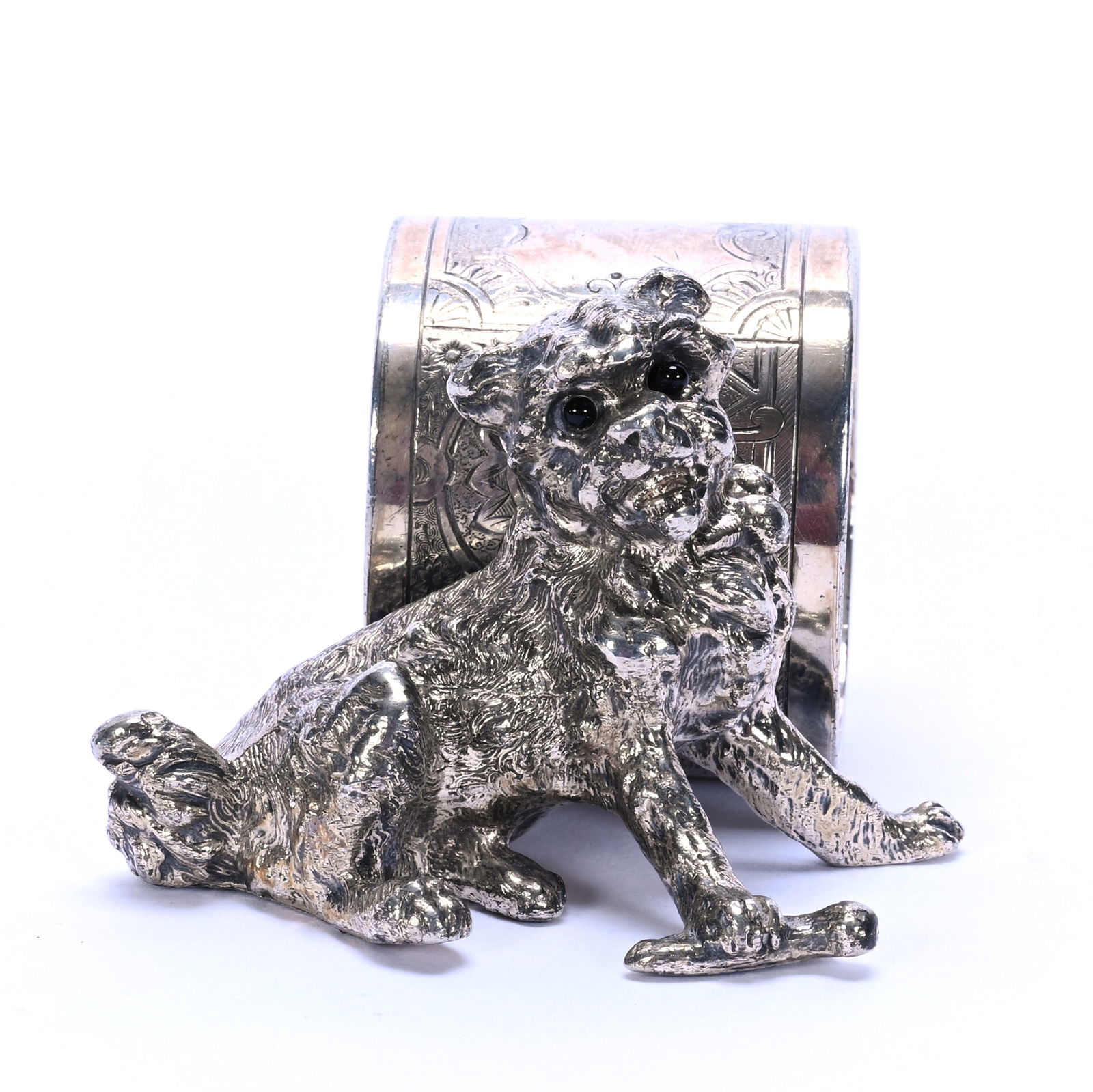 Silverplate Figural Napkin Ring, Unmarked: Silverplate Figural Napkin Ring, Unmarked, 2 x 3 x 3 Inches, Dog With Bone, Amber Glass Eyes, 0.3 Pounds, Dr. Harold & Audrey Eklund Estate, Iowa.