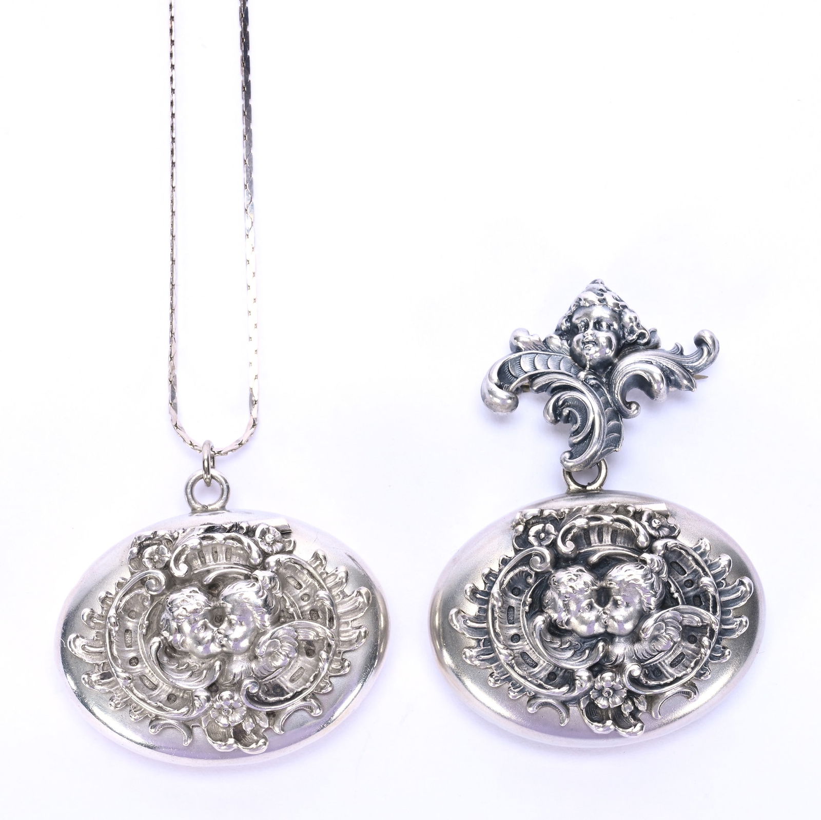 (2) Solid Sterling Silver Lockets Marked Kerr & Company: (2) Solid Sterling Silver Lockets Marked Kerr & Company, 1.25 x 1.5 x 0.5 Inches, Winged Cherub Design, One Locket Is Broach, One Locket On Chain As Pendant, 27.0 Grams, Dr. Harold & Audrey Eklund
