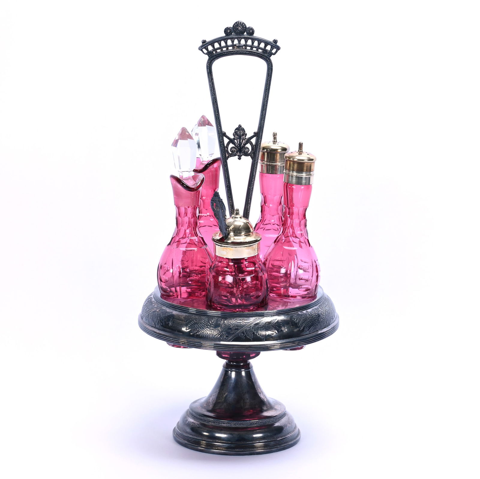 Castor Set, Cranberry Art Glass Inserts: Castor Set, Cranberry Art Glass Inserts, 15.75 x 7.25 x 7.25 Inches, Set On Unmarked Silverplate Revolving Stand, Silverplate Base Has Been Epoxy Filled To Make It Weighted, The Mustard Insert Has A B