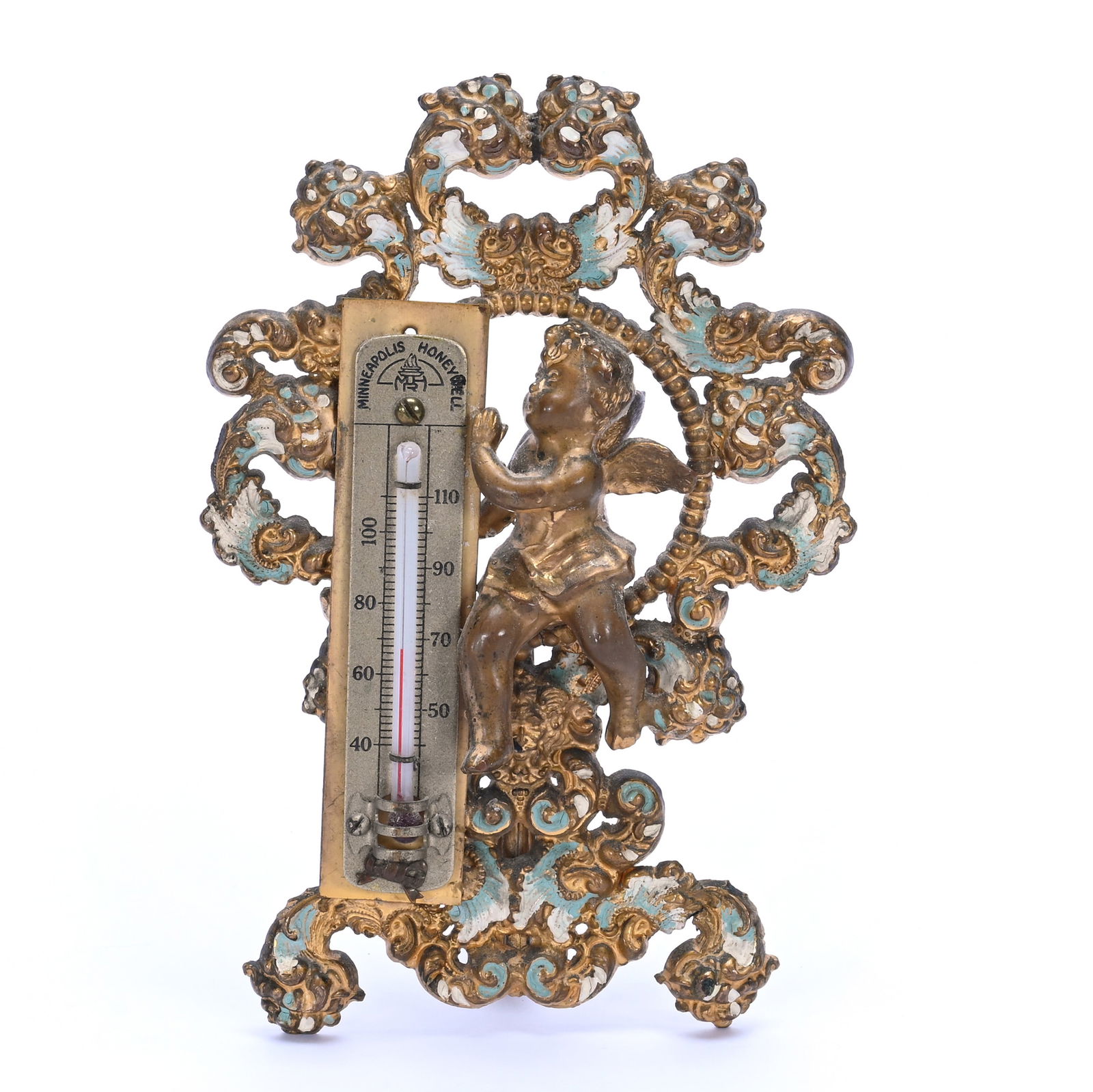 Thermometer: Thermometer, 6.5 x 4.5 x 2.5 Inches, Unmarked Solid Brass With Figure Of Cherub With Enamel Highlights, One Replacement Nut On Backside, 0.9 Pounds, Grady And Annette Hite Collection.