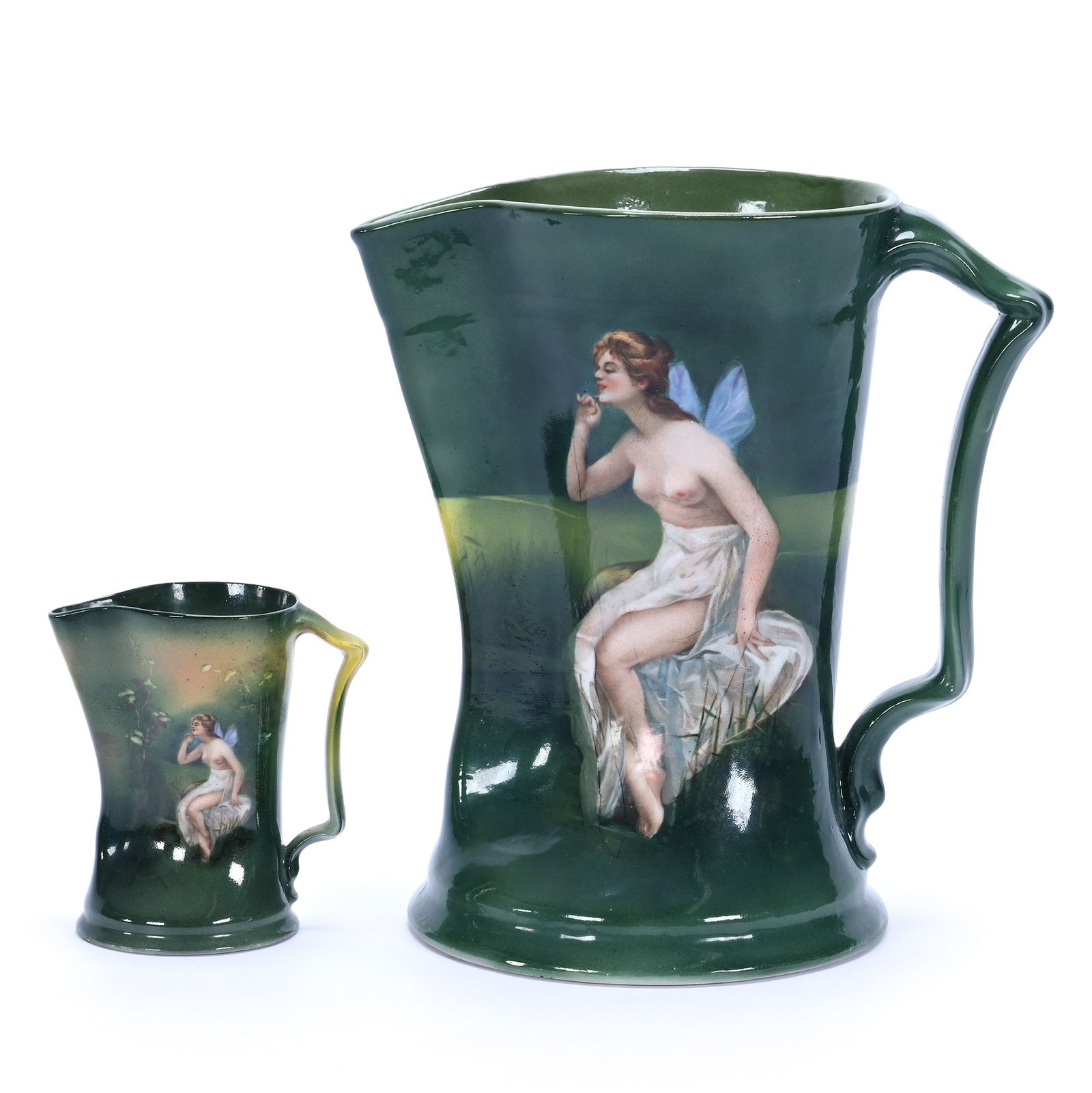 (2) Pitchers, Royal Bayreuth Blue Mark: (2) Pitchers, Royal Bayreuth Blue Mark Green Tones With Nymph Scenic Decor, (1) 8.25" x 7.75" Water Pitcher, (1) 3.75" x 3.5" Creamer, 2.6 Pounds, Grady And Annette Hite Collection.