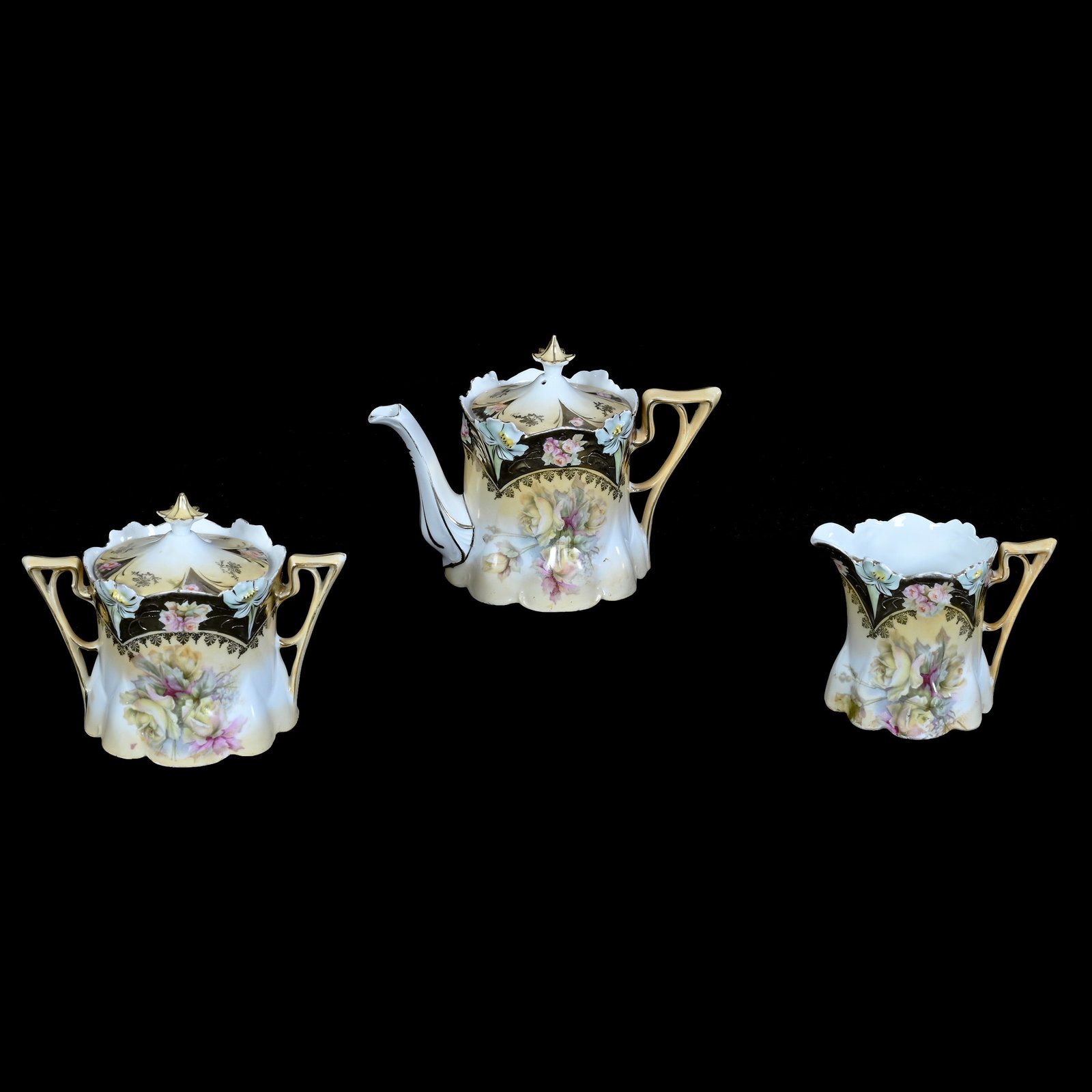 (3) Piece Tea Set, Unmarked R.S. Prussia, Lily Mold: (3) Piece Tea Set, Unmarked R.S. Prussia, Lily Mold, 5.25 x 7.5 x 4.25 Inches, Cream And White Tones With Yellow Rose Decor And Heavy Gold Border, Teapot With Creamer, And Sugar, Teapot Has Hard To Se