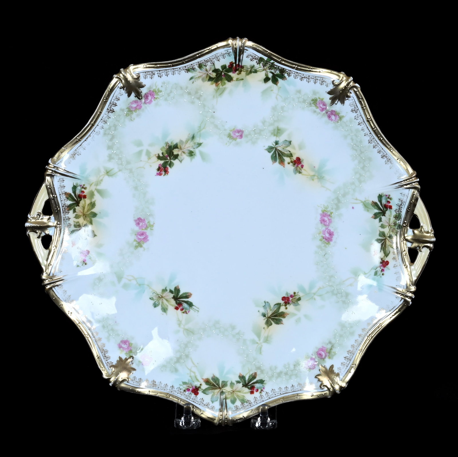 Two Handled Cake Plate, Marked R.S. Prussia: Two Handled Cake Plate, Marked R.S. Prussia, 11.75 x 11.25 x 1.25 Inches, White And Green Tones With Berry And Leaf Decor, Backside Rim Chip Repair, 1.1 Pounds. LiveAuctioneers Invoices Must Be Paid