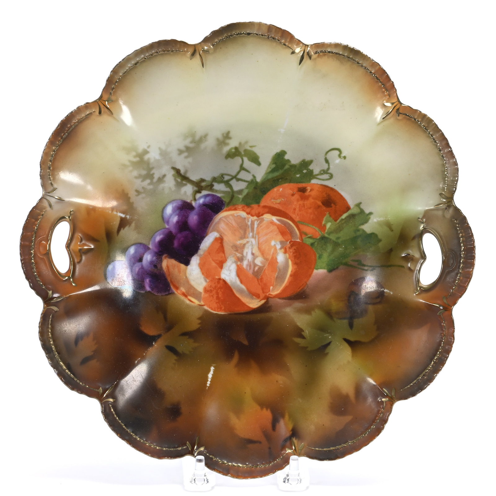 Two Handled Cake Plate, Unmarked R.S. Prussia: Two Handled Cake Plate, Unmarked R.S. Prussia, 10.75 x 10.75 x 1.25 Inches, Brown And Yellow Tones With Fruit Decor, 0.9 Pounds. LiveAuctioneers Invoices Must Be Paid Using the PAY NOW / CHECK OUT