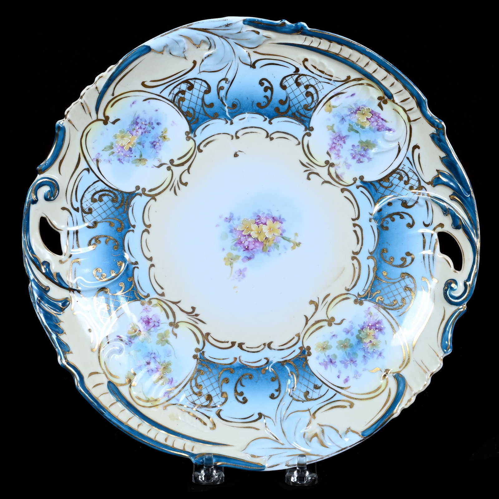 Two Handled Cake Plate, Unmarked R.S. Prussia: Two Handled Cake Plate, Unmarked R.S. Prussia, 11 x 10.75 x 1.5 Inches, Cream And Blue Tones With Floral Decor And Gold Stencil Highlights, Rim Hairline, 1.2 Pounds. LiveAuctioneers Invoices Must Be