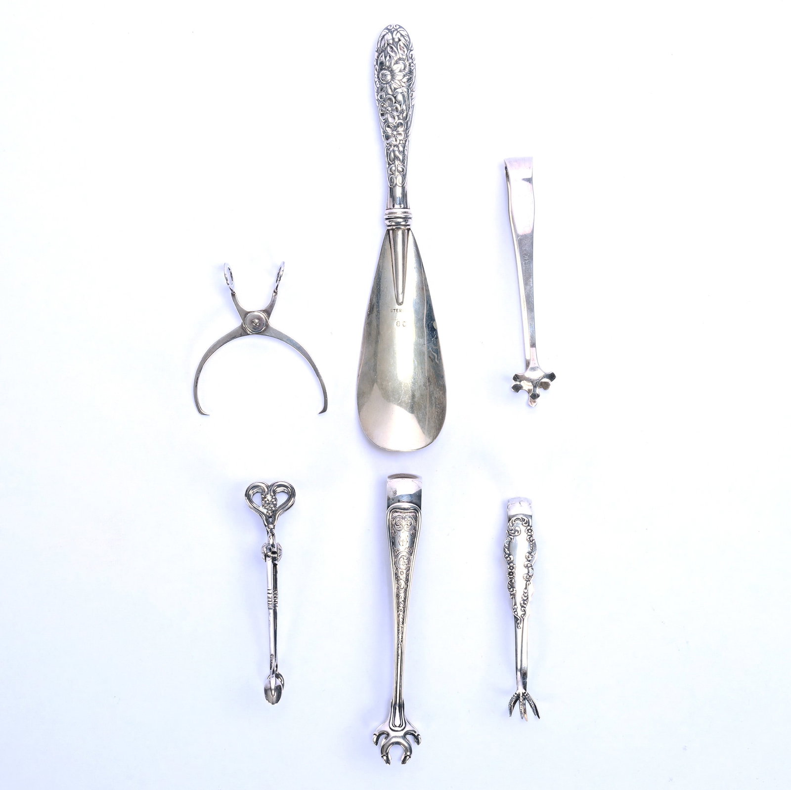 (6) Sterling Silver Novelty Items: (6) Sterling Silver Novelty Items, 7.5 x 2.5 x 1 Inches, (1) 7.5" Shoe Horn, (5) Miscellaneous Tongs, Sizes Ranging From 5" Down To 3", 160 Grams, Grady and Annette Hite Collection, North Carolina.