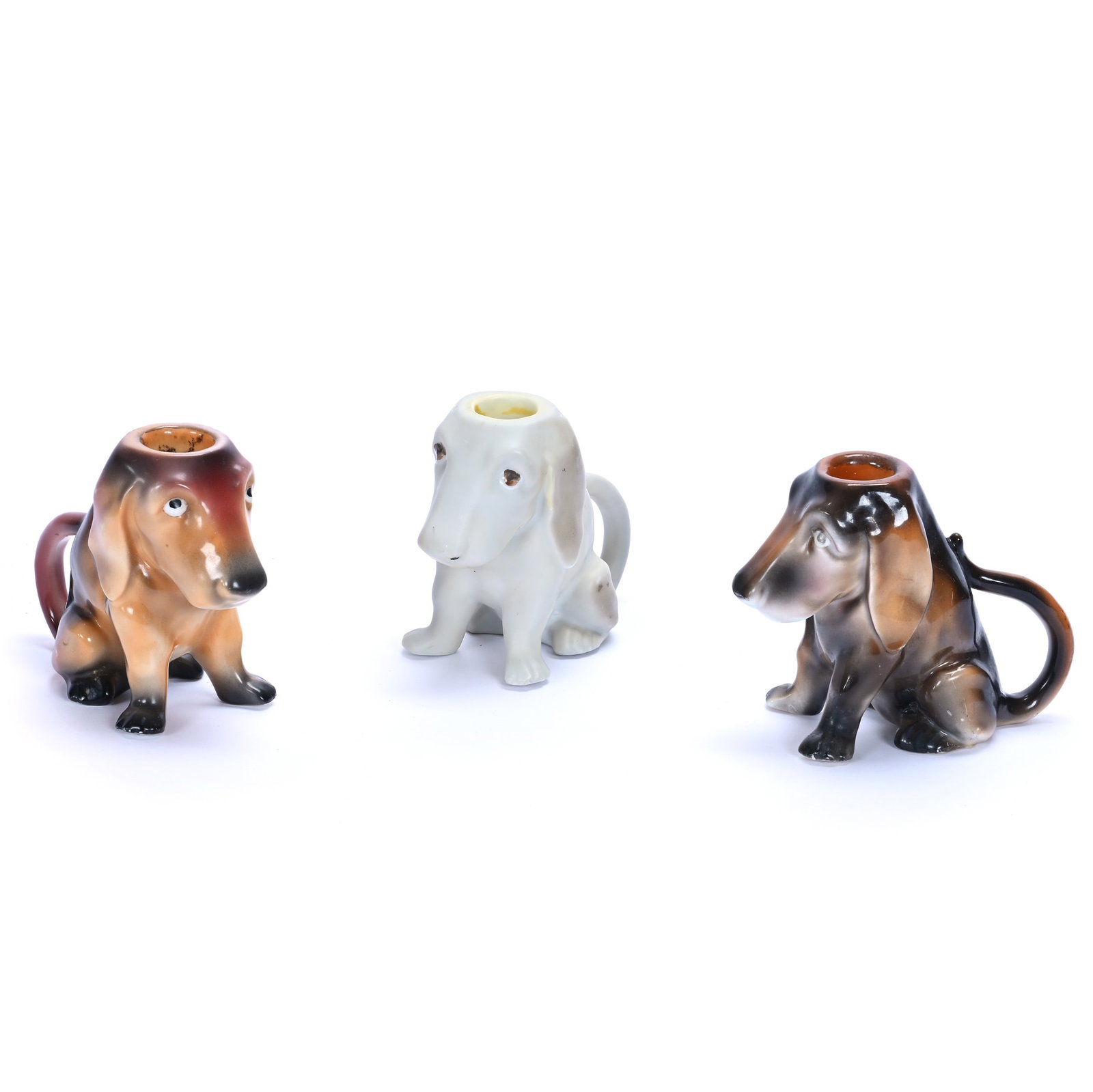 (3) Figural Chamber Sticks, Royal Bayreuth Blue Mark Dachshund: (3) Figural Chamber Sticks, Royal Bayreuth Blue Mark Dachshund, 4.25 x 5.25 x 2.5 Inches, (2) Brown Tones And (1) White Satin With Faded Mark, 1.2 Pounds, Grady and Annette Hite Collection, North