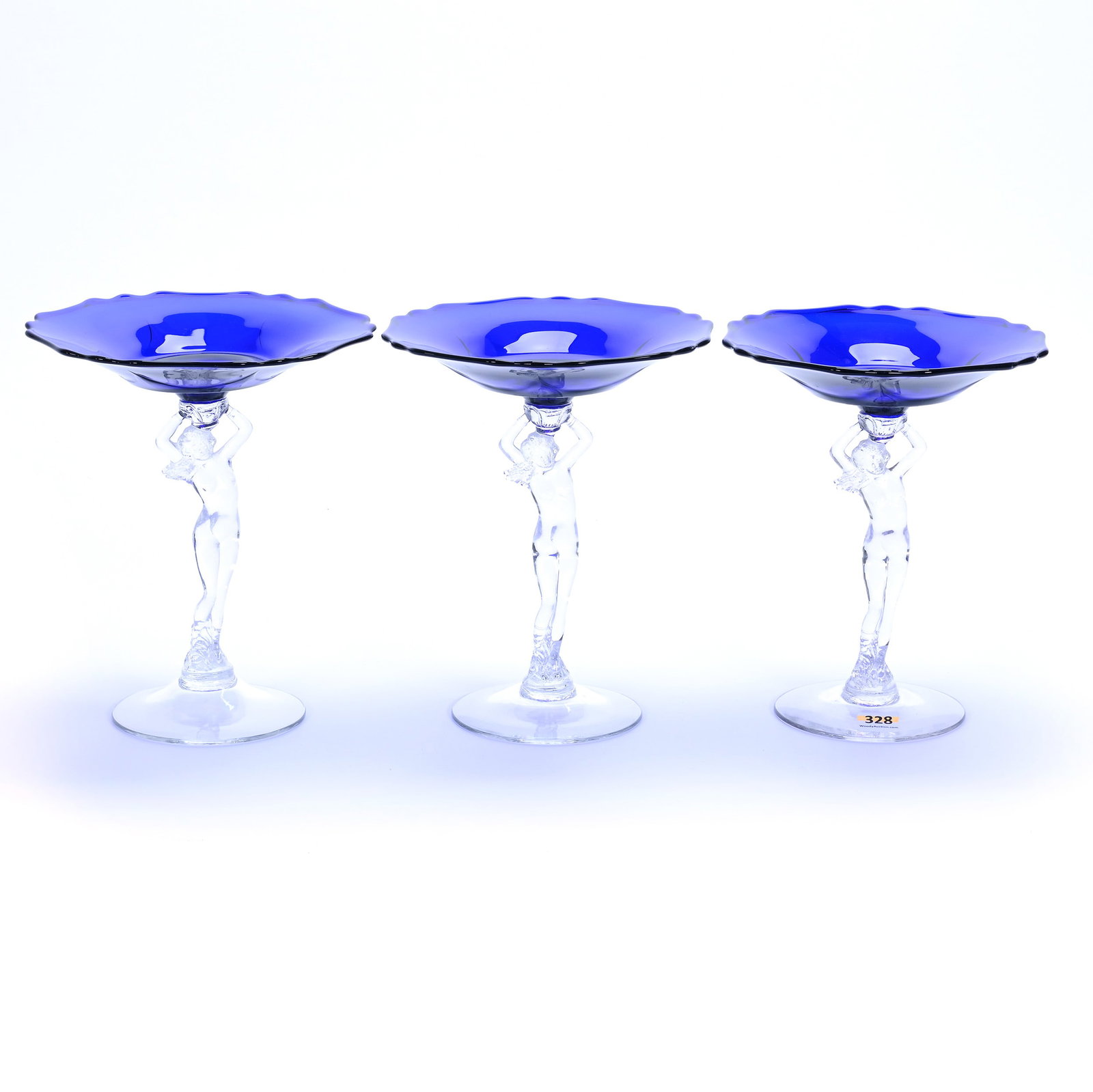 (3) Figural Compotes, Cambridge Statuesque Line: (3) Figural Compotes, Cambridge Statuesque Line, 8 x 7 x 7 Inches, Cobalt Blue Bowls With Clear Figural Nude Stems And Foot, 2.9 Pounds, Grady and Annette Hite Collection, North Carolina. Effective