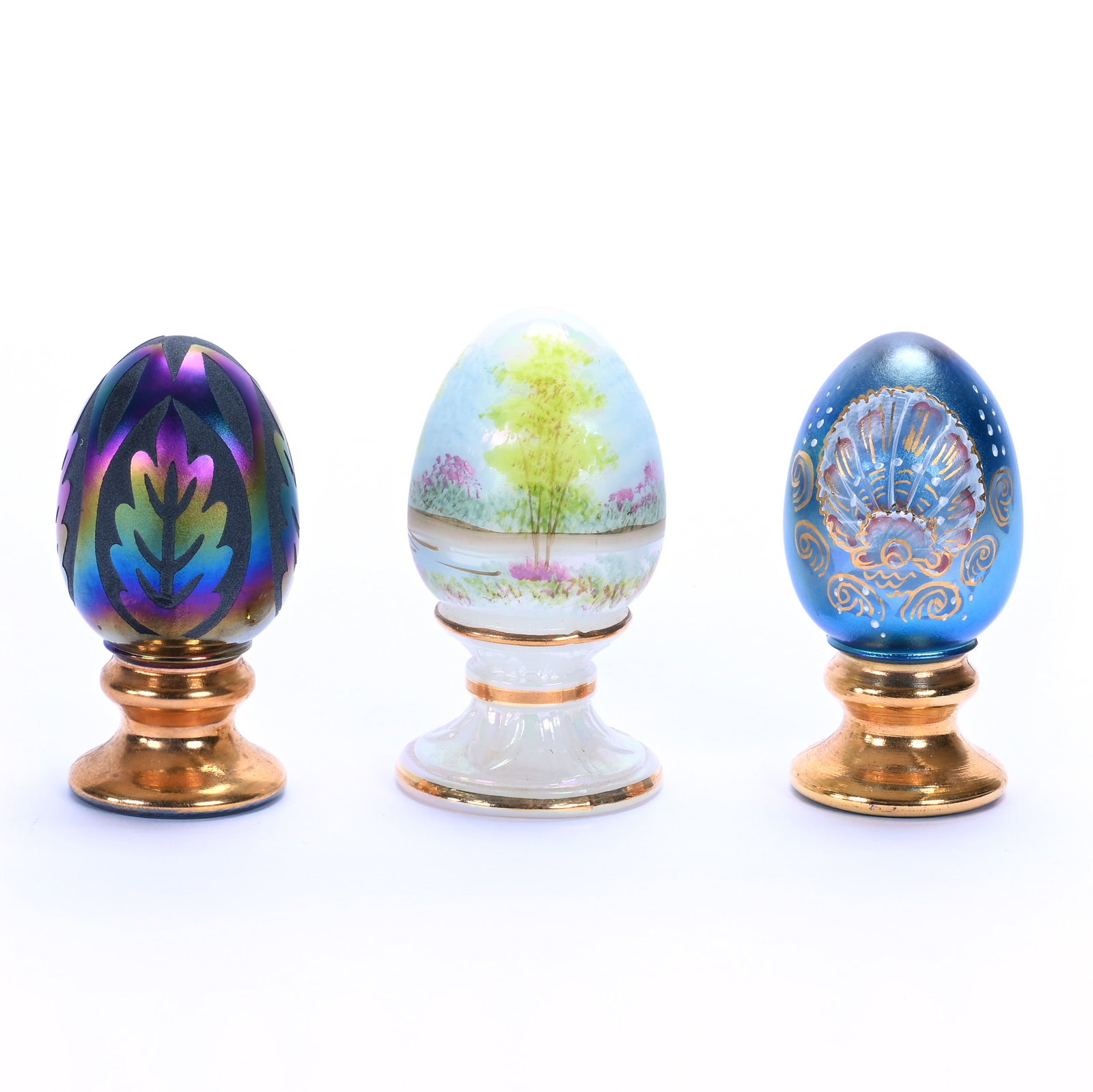 (3) Pedestal Eggs, Fenton Art Glass Limited Edition: (3) Pedestal Eggs, Fenton Art Glass Limited Edition, 3.5 x 2 x 2 Inches, (1) White Hand Painted #1619 Of 2500, (1) Iridescent Blue With Hand Painted Shell Decor, #752 Of 1500, And (1) Iridescent Sand 