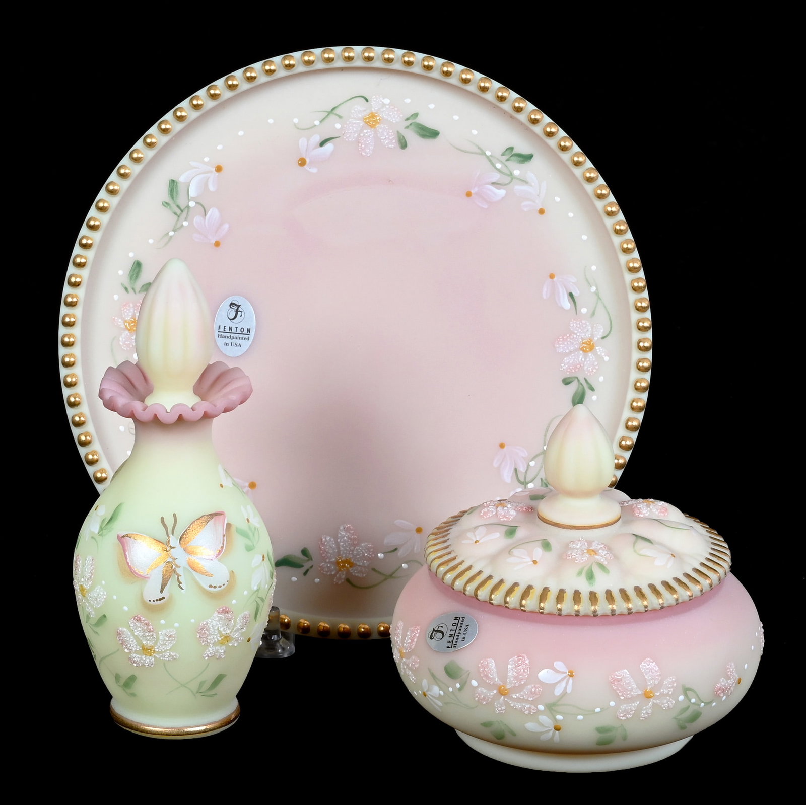 (3) Piece Vanity Set, Burmese Art Glass By Fenton: (3) Piece Vanity Set, Burmese Art Glass By Fenton, 6 x 7 x 7 Inches, Hand Painted Floral And Butterfly Decor, Sells With Original Box, Highly Reactive Under Blacklight, Artist Signed, 2.3 Pounds, Haze