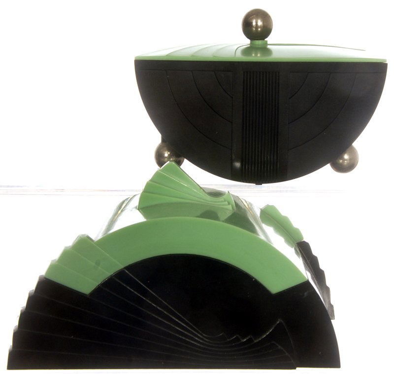 (2) BAKELITE ART DECO DESIGN CIGARETTE CONTAINERS - CIR: (2) BAKELITE ART DECO DESIGN CIGARETTE CONTAINERS - CIRCA 1930'S (1) BLACK WITH GREEN LID - SILVER COLORED FEET AND FINIAL - 1933 WORLD'S FAIR GE MARK; (1) BLACK WITH GREEN LID - FAN SHAPED FINIAL