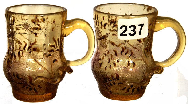 PAIR 2 1/2" SIGNED "E. GALLE" FRENCH ART GLASS HANDLED: PAIR 2 1/2" SIGNED "E. GALLE" FRENCH ART GLASS HANDLED MUGS AMBER WITH ENAMEL GRASSHOPPER AND BLOSSOM DECOR - LONG APPLIED GLASS "TAIL" EXTENDING FROM HANDLE