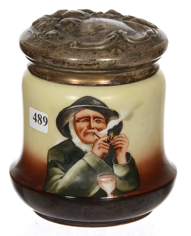 6" OPAQUE ART GLASS HUMIDOR: 6" OPAQUE ART GLASS HUMIDOR HUMIDOR HAS SCENE OF OLD SEAMAN LIGHTING PIPE WITH GOBLET SITTING IN FRONT OF HIM - EMBOSSED METAL LID WITH FLORAL DECOR - LID COVERS ROUGHNESS AROUND RIM OF HUMIDOR