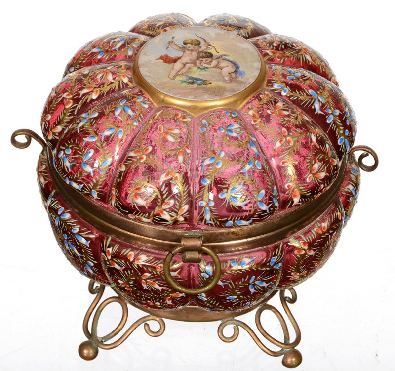 4 1/2" X 5" FOOTED ART GLASS ROUND HINGED BOX: 4 1/2" X 5" FOOTED ART GLASS ROUND HINGED BOX CRANBERRY WITH ALL OVER MOSER STYLE ENAMEL DECOR - CENTER OF LID IS PORCELAIN WITH TWO CHERUBS LOOKING DOWN FROM CLOUDS - METAL BASE, RIM AND FEET