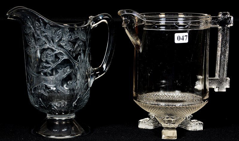 (2) 8 1/2" PATTERN GLASS WATER PITCHERS: (2) 8 1/2" PATTERN GLASS WATER PITCHERS (1) EMBOSSED DOG BARKING AT BIRD IN TREE - (1) DRUM/BARREL SHAPE WITH EMBOSSED FIGURE SPOUT