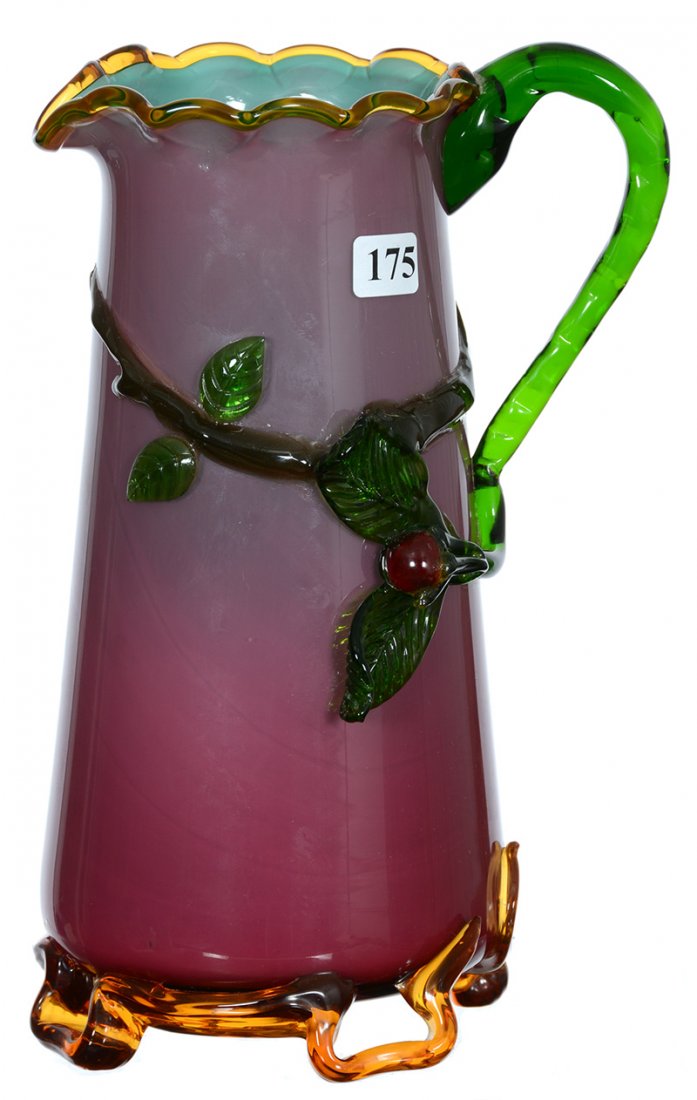 10 1/4" STEVENS & WILLIAMS STYLE CASED ART GLASS WATER: 10 1/4" STEVENS & WILLIAMS STYLE CASED ART GLASS WATER PITCHER DARK PINK EXTERIOR - BLUE INTERIOR - APPLIED GREEN HANDLE AND BRANCH - SECTION OF BRANCH REPLACED - CRACK IN HANDLE