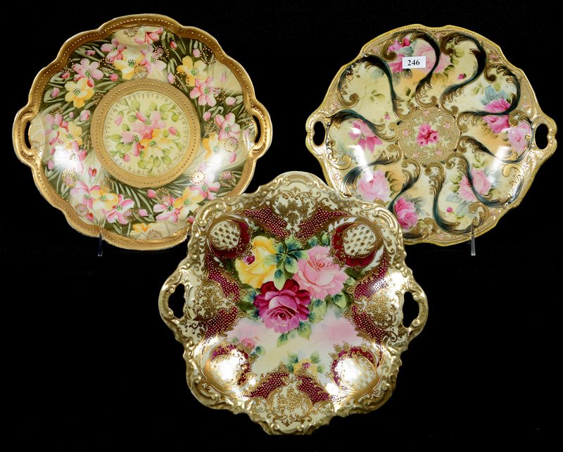 (3) NIPPON TWO-HANDLED CAKE PLATES: (3) NIPPON TWO-HANDLED CAKE PLATES - (1) 10.5" SWIRL DESIGN - (1) 11" WITH PINK AND YELLOW BLOSSOMS ON GREEN FIELD (OLD CROW'S FOOT) - (1) 11.25", ROSE DECOR WITH RED AND GOLD BORDER