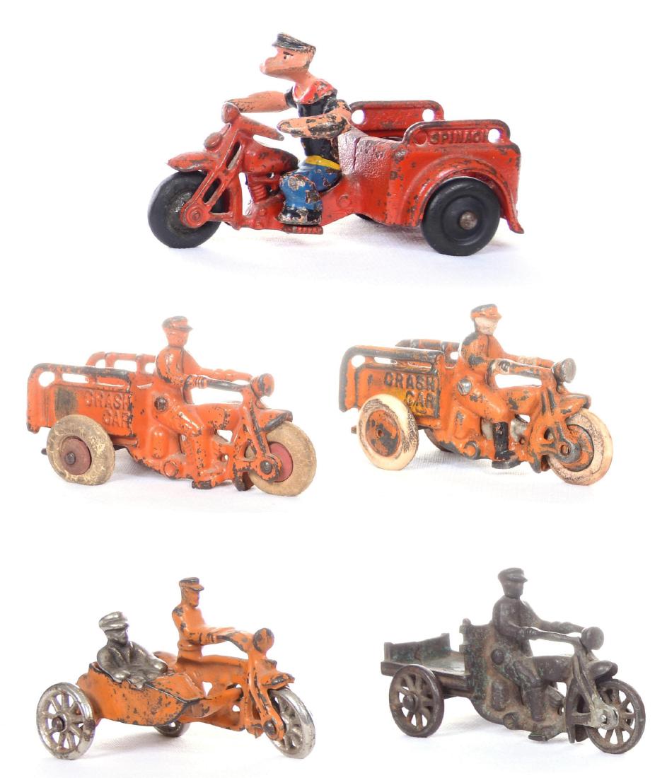 (5) CAST IRON MOTORCYCLE RELATED TOYS INCLUDING: (2) 4.5" ORANGE TRICYCLE GEAR CRASH CARS - (1) 4.5" TRICYCLE FLAT BED - (1) 5.5" POPEYE TRICYCLE SPINACH CAR - (1) 4" MOTORCYCLE POLICEMAN WITH SIDE CAR