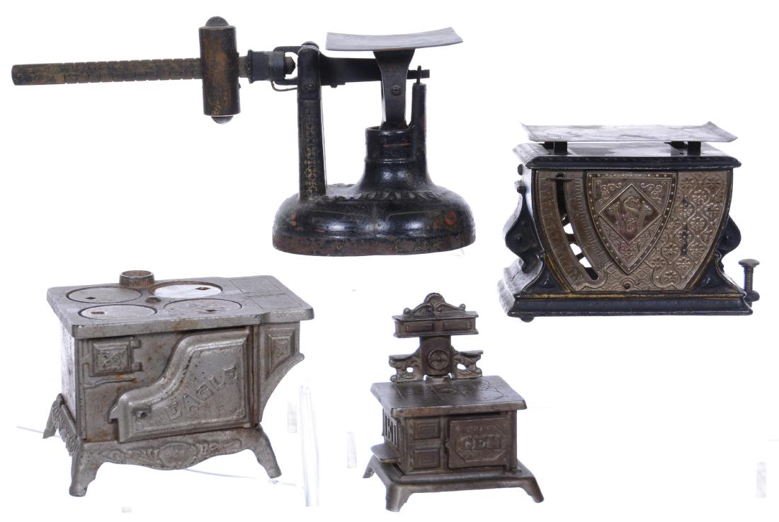 (4) CAST IRON ITEMS INCLUDING: (1) 4.75" X 9" FAIRBANKS BALANCE SCALE - (1) WEAVER SCALE - (1) 3" X 4.75" EAGLE TOY STOVE - (1) 3.75" X 3" "GEM" TOY STOVE 