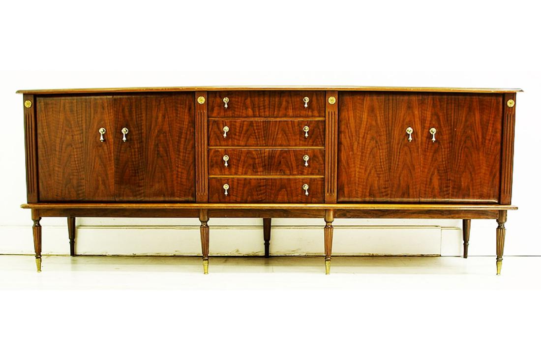 Mahogany Credenza: English mahogany credenza with two pairs of lateral doors flanking a central course of 4 drawers on reeded legs. Circa 1940. Approx. 33" tall 86½" wide 19½" deep.