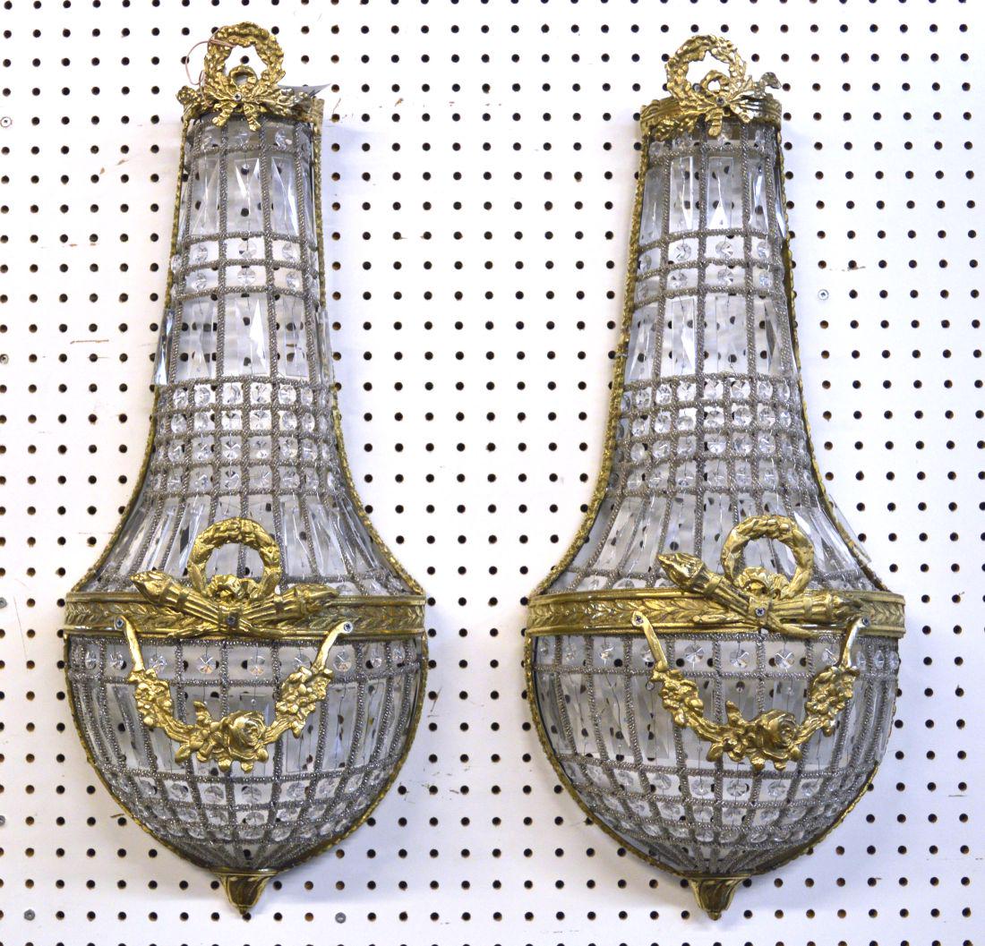 Pair of Louis XVI-style wall sconces: Pair of Louis XVI-style gilt ormolu and crystal wall sconces of tear drop form, decorated with laurel wreath and floral swag ornaments. Height: 27". Width: 12".