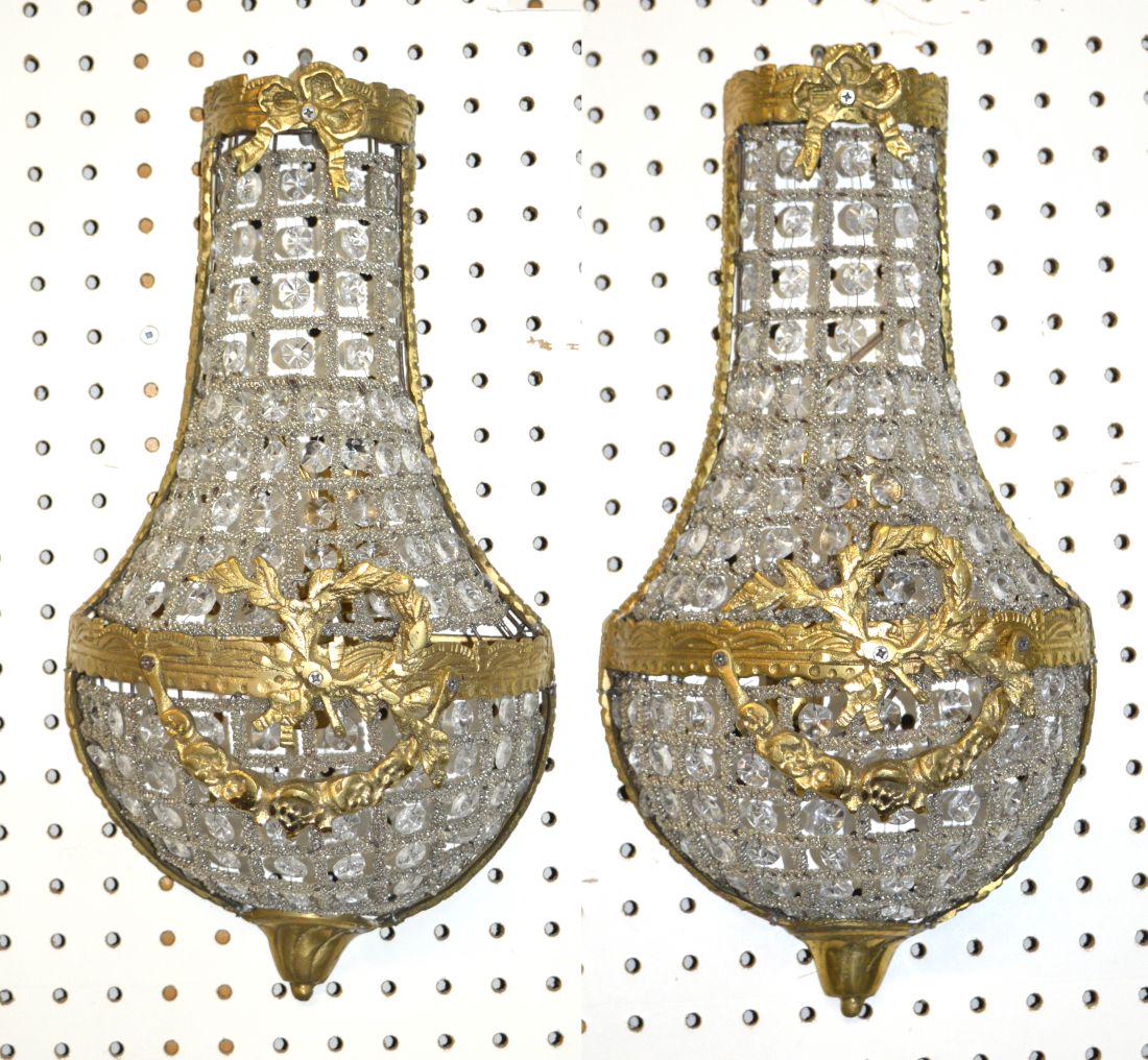 Louis XVI-style wall sconces: Pair of Louis XVI-style gilt ormolu and crystal wall sconces of tear drop form, decorated with laurel wreath and floral swag ornaments. 17" tall.