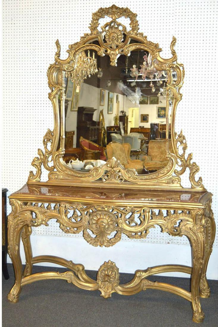Rococo-style console and mirror: Exquisite Rococo-style hand-carved console and matching mirror, fitted with a marble top; decorated overall in a gilt finish with extensive foliate and floral carvings. Console: 71" wide, 37" tall, 20